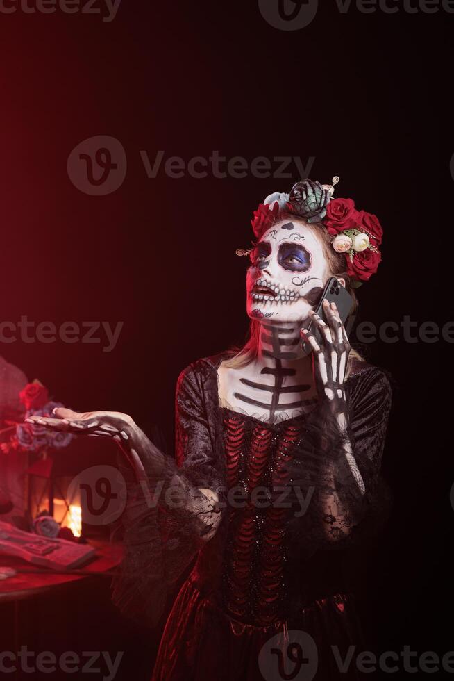 Woman having fight with mates in call at Day of the Dead event to remember the deceased. Lady arguing with friends in telephone call during Mexican holiday of remembrance for those who have passed photo