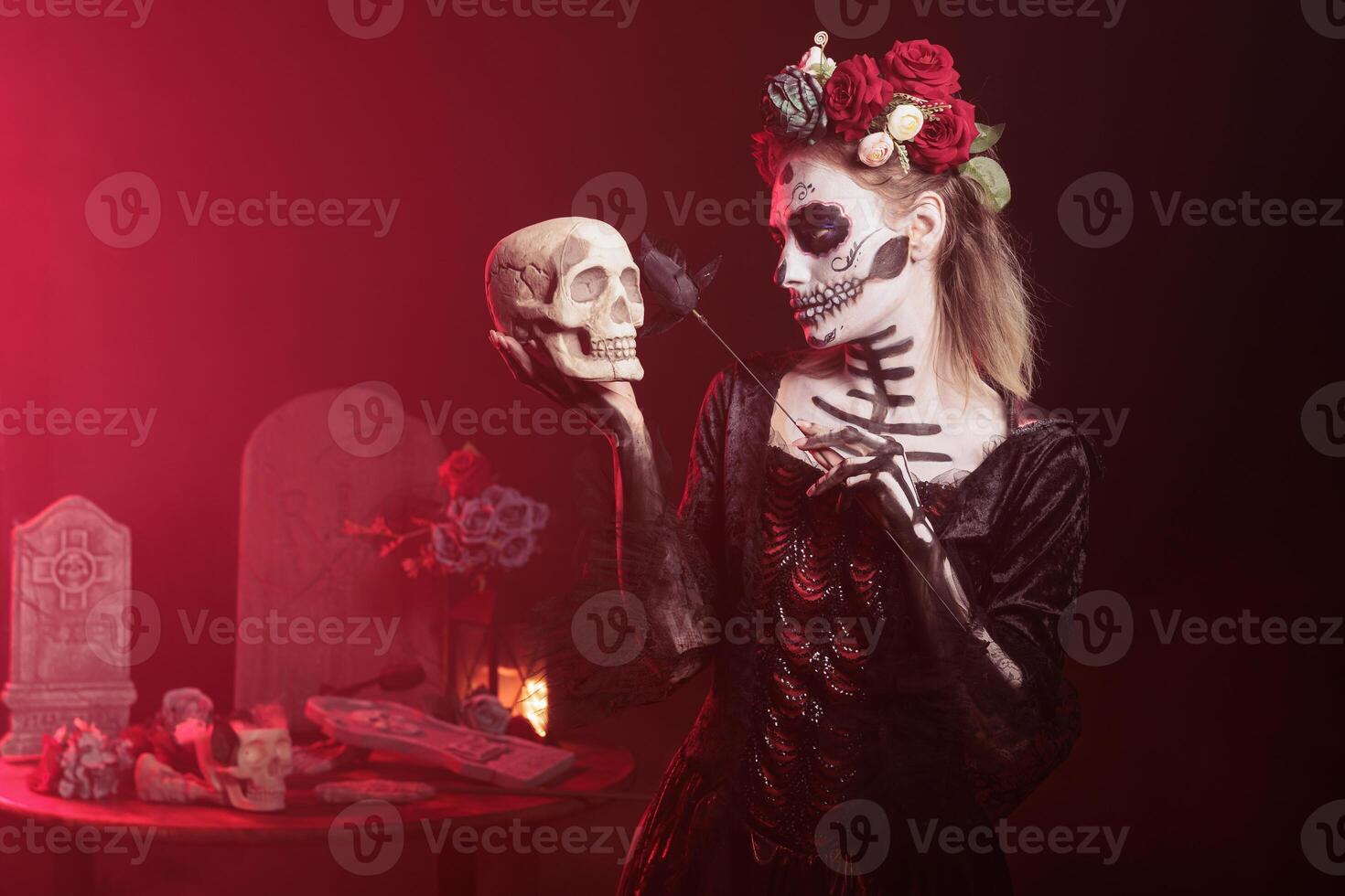 Woman doing Hamlet scene at Day of the Dead event to remember the deceased. Lady posing with skull in hand at theatre play for Mexican holiday of remembrance for those who have passed photo