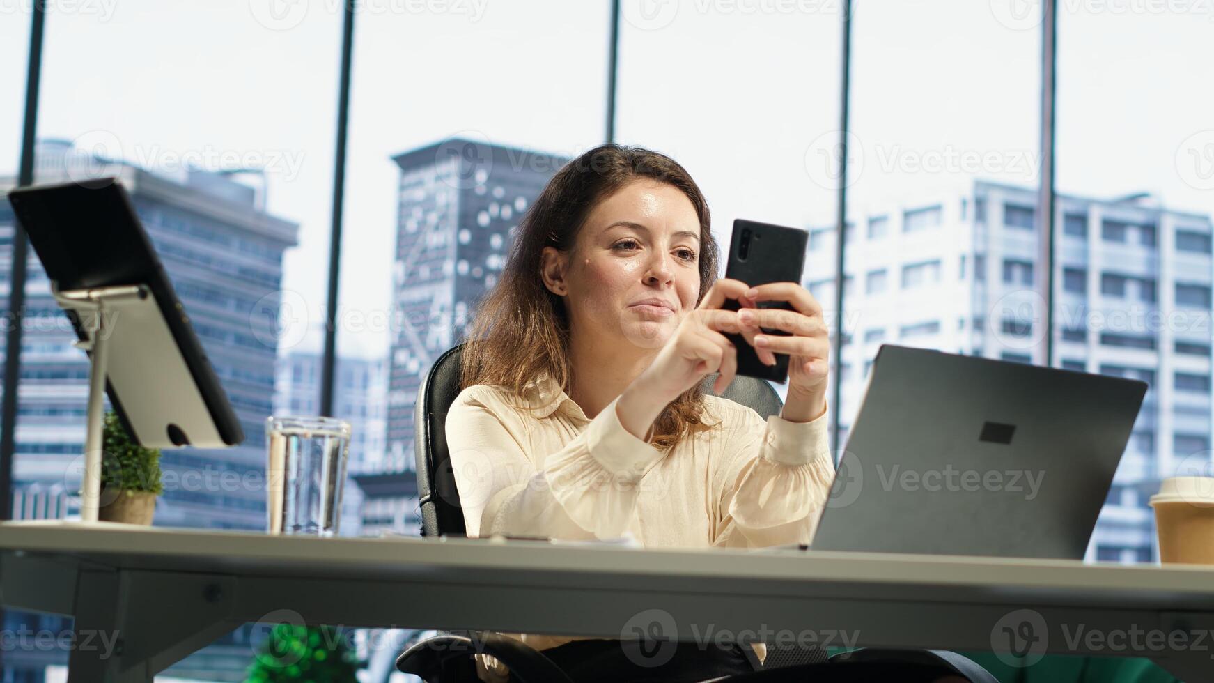 Business director texting messages and discussing about enterprise performance, sharing insight on updates and details. Young entrepreneur using her personal phone on social media. Camera A. photo