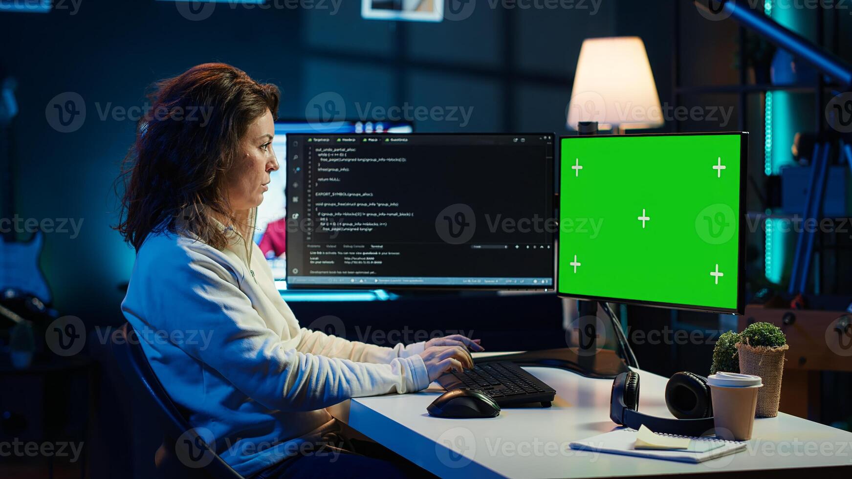 Developer doing software debugging on green screen PC at home, checking lines of code displayed on monitors. IT professional in living room fixing coding problems on mockup computer, camera A photo