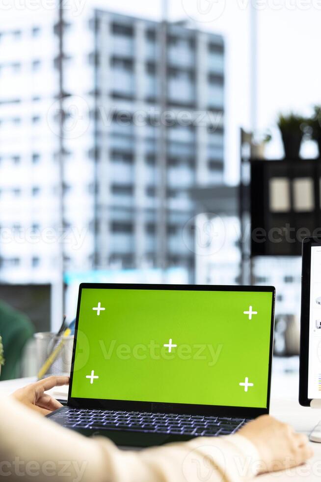 Woman company leader looking at isolated chroma key display in high end urban office, ambitious driven CEO with executive power. Businesswoman with strategic thinking in corporation. photo