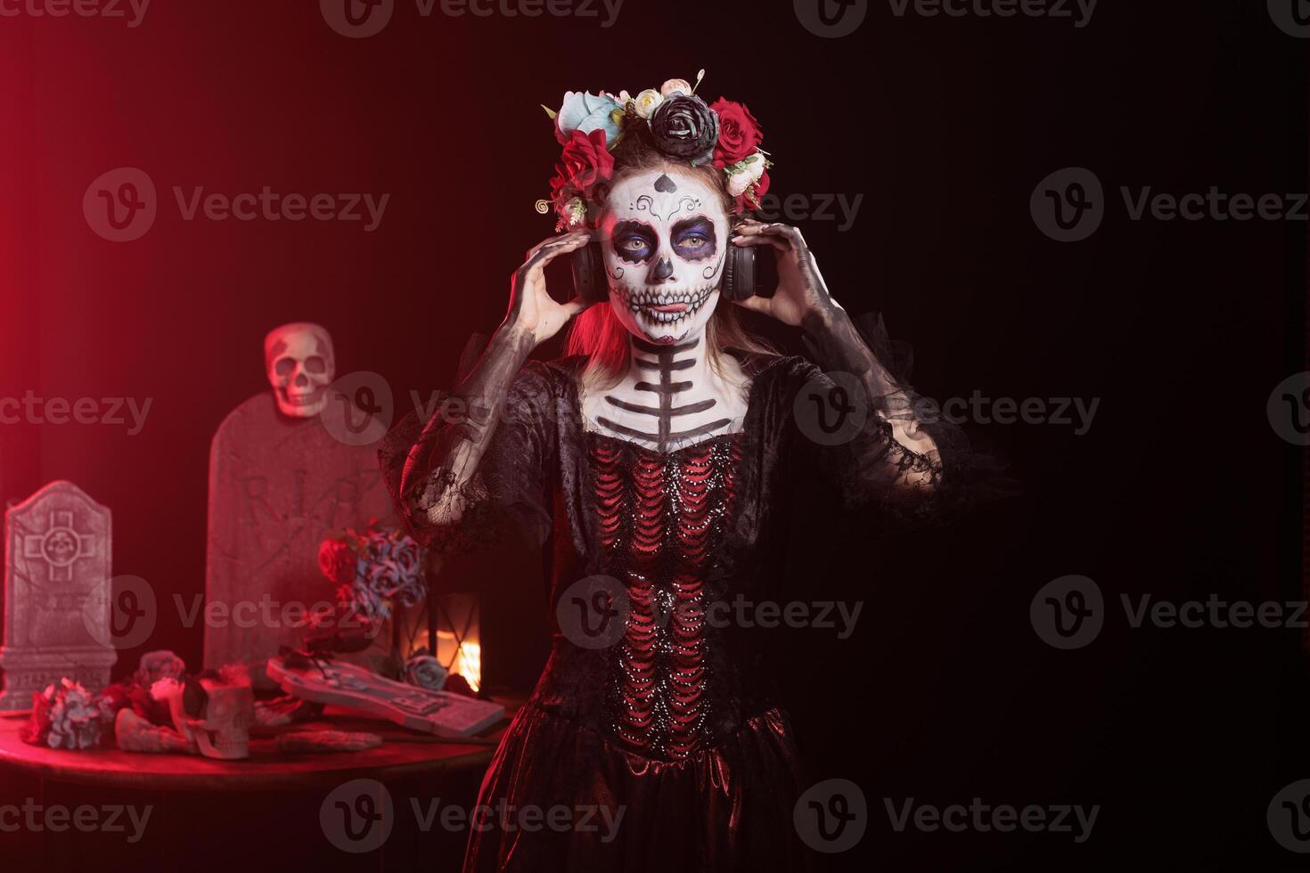 Woman wearing headphones, hearing songs at Day of the Dead event to remember the deceased. Lady listening music during Mexican holiday of remembrance for those who have passed photo