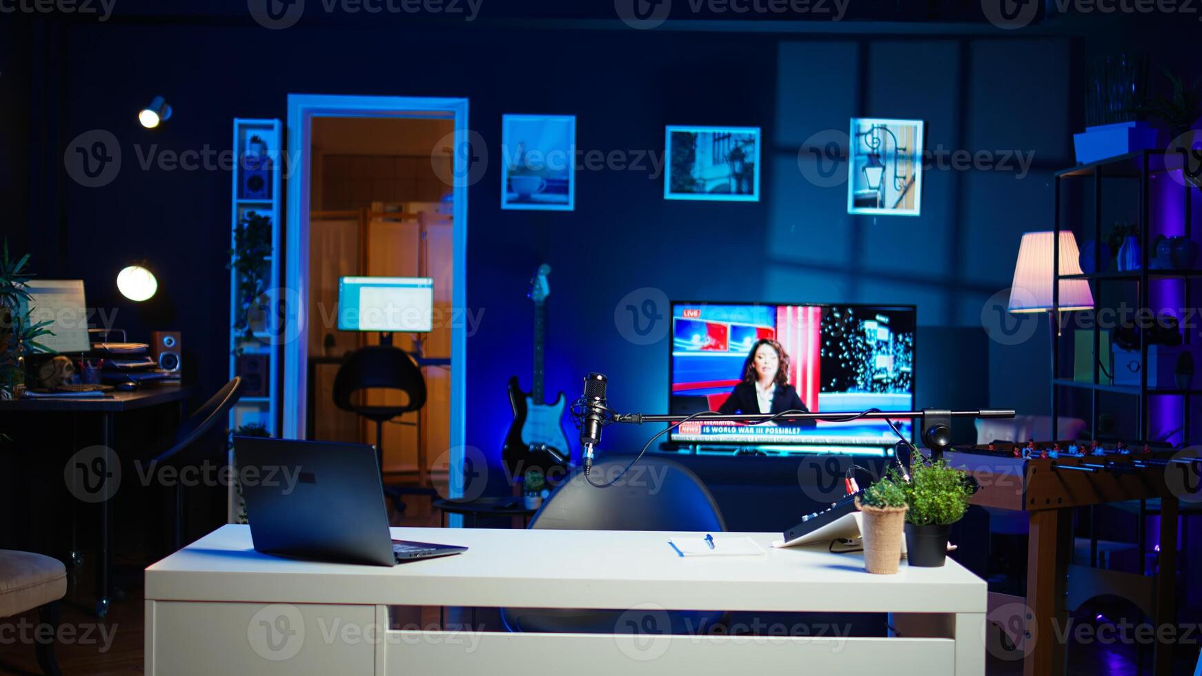 TV screen showing news broadcast and recording gear in empty home studio interior. Dolly out shot of streaming equipment in modern apartment illuminated with RGB lights at night photo