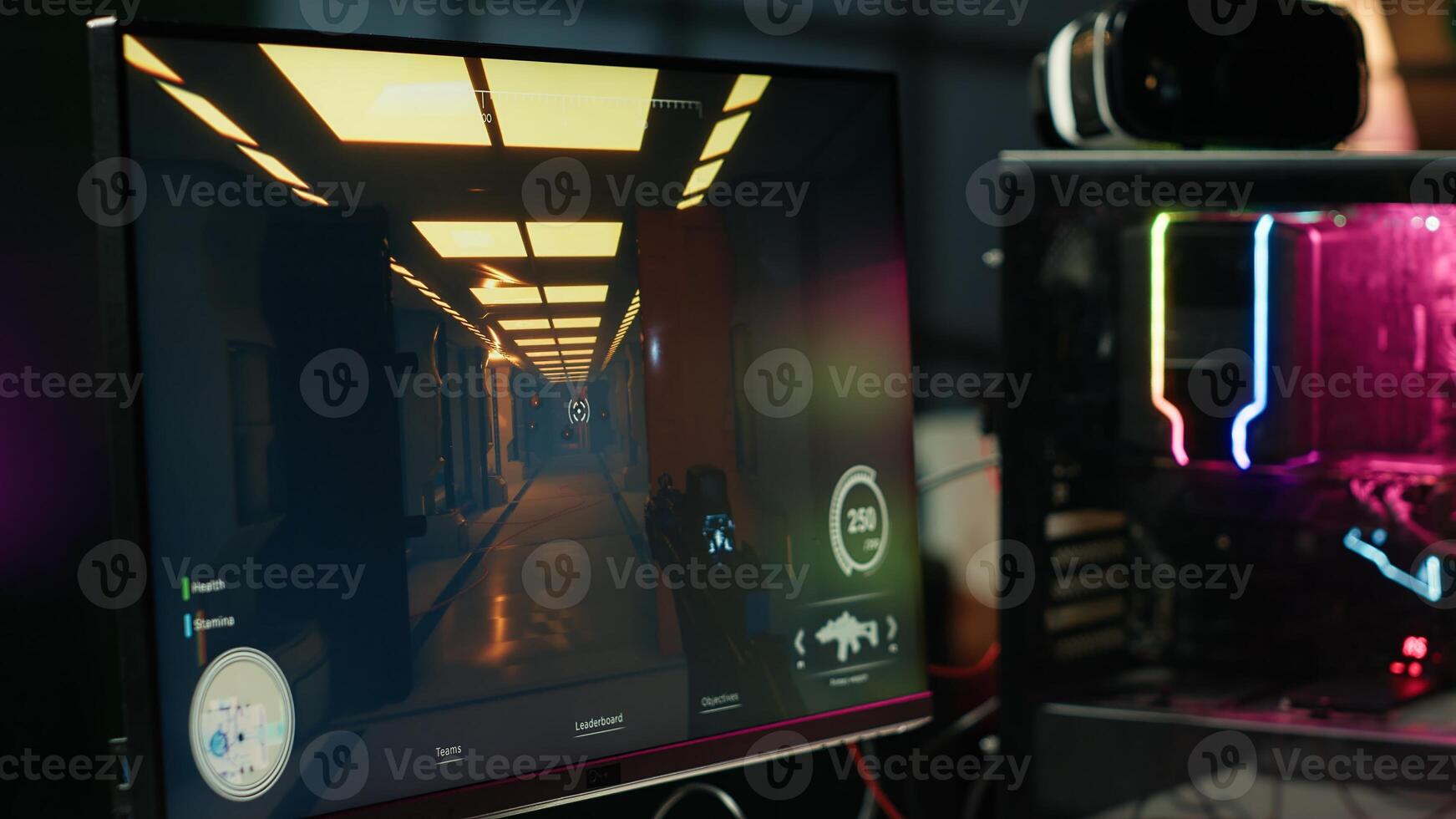 Computer screen showing first person shooter game left open at night in empty apartment with neon lights. Close up of PC on desk in living room with no people in and display left open photo