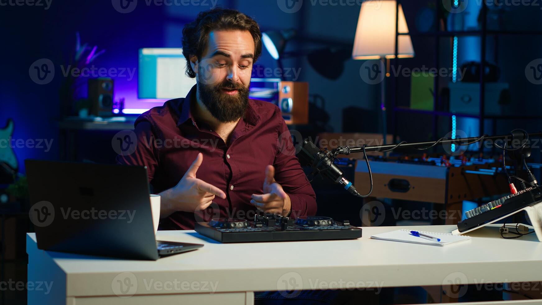 Artist filming DJ mixing tutorial, showing examples of sampling on sound controller to viewers. Viral online star showing modern musical equipment to subscribers in home studio, camera A photo