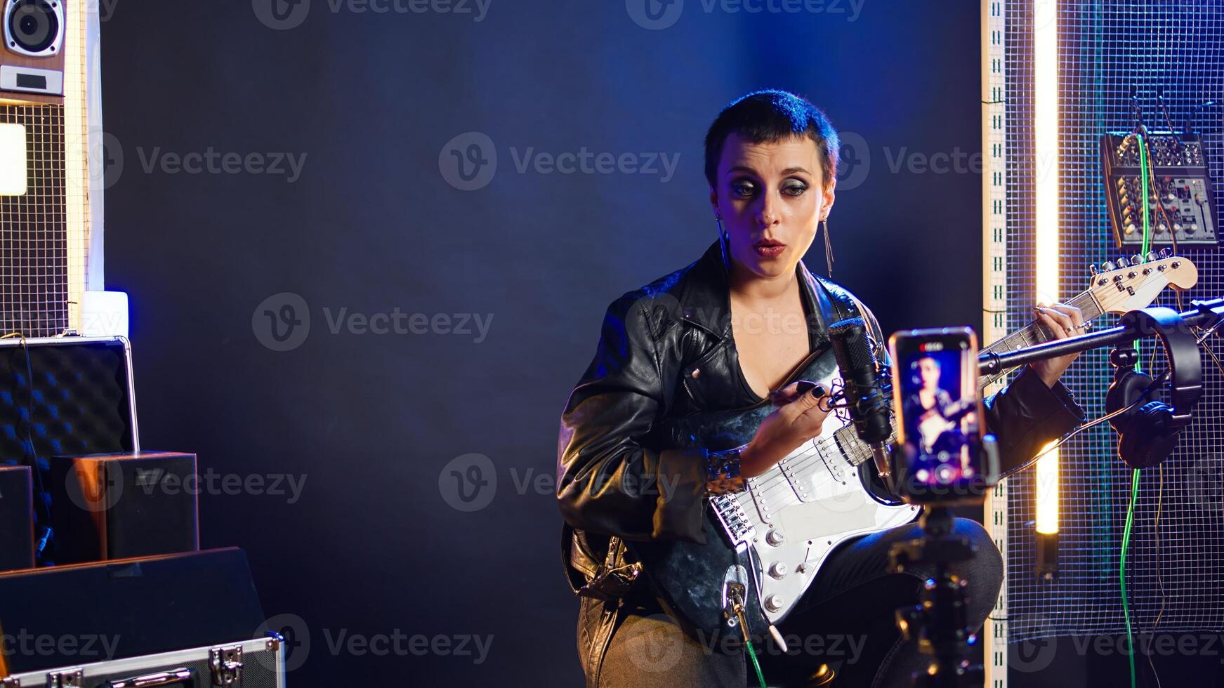 Singing coach recording an online lesson for voice training in studio, vocal exercises on live stream tutorial. Musical instructor with a heavy metal vibe teaching the basics. Camera A. photo