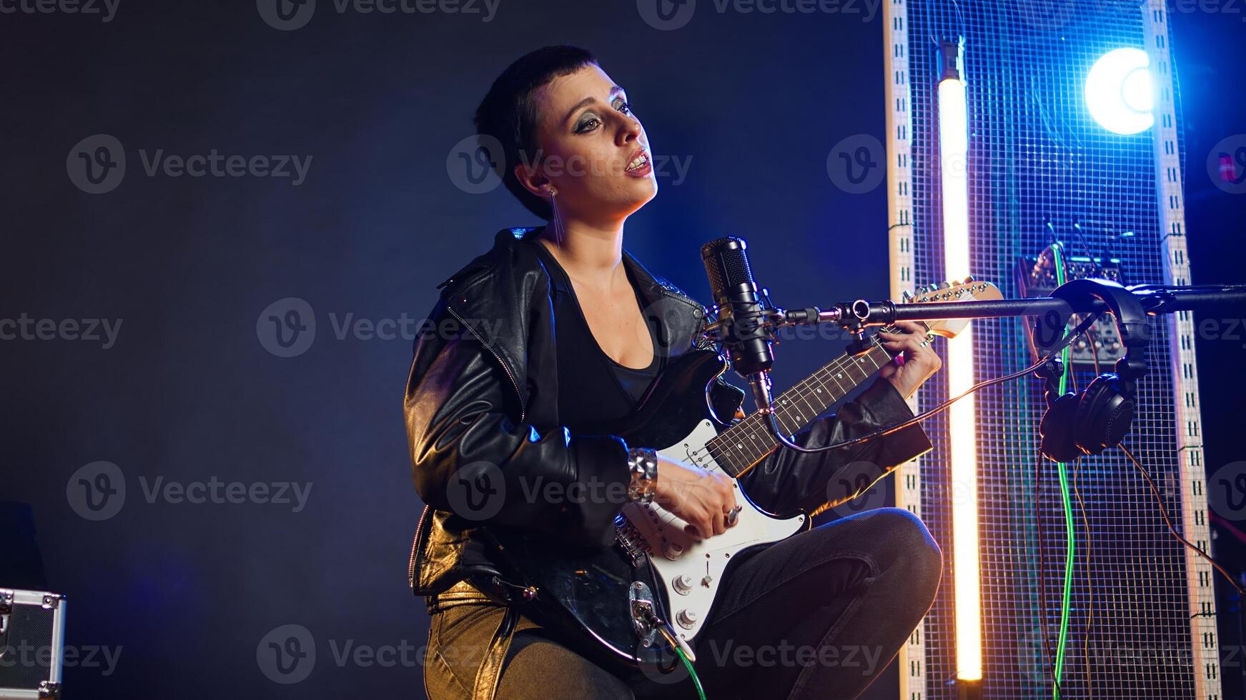 Confident female singer delivers a powerful vocal performance in a live show. Edgy heavy metal artist with rock star vibes performing a live song, iconic artist singing alternative music. Camera A. photo