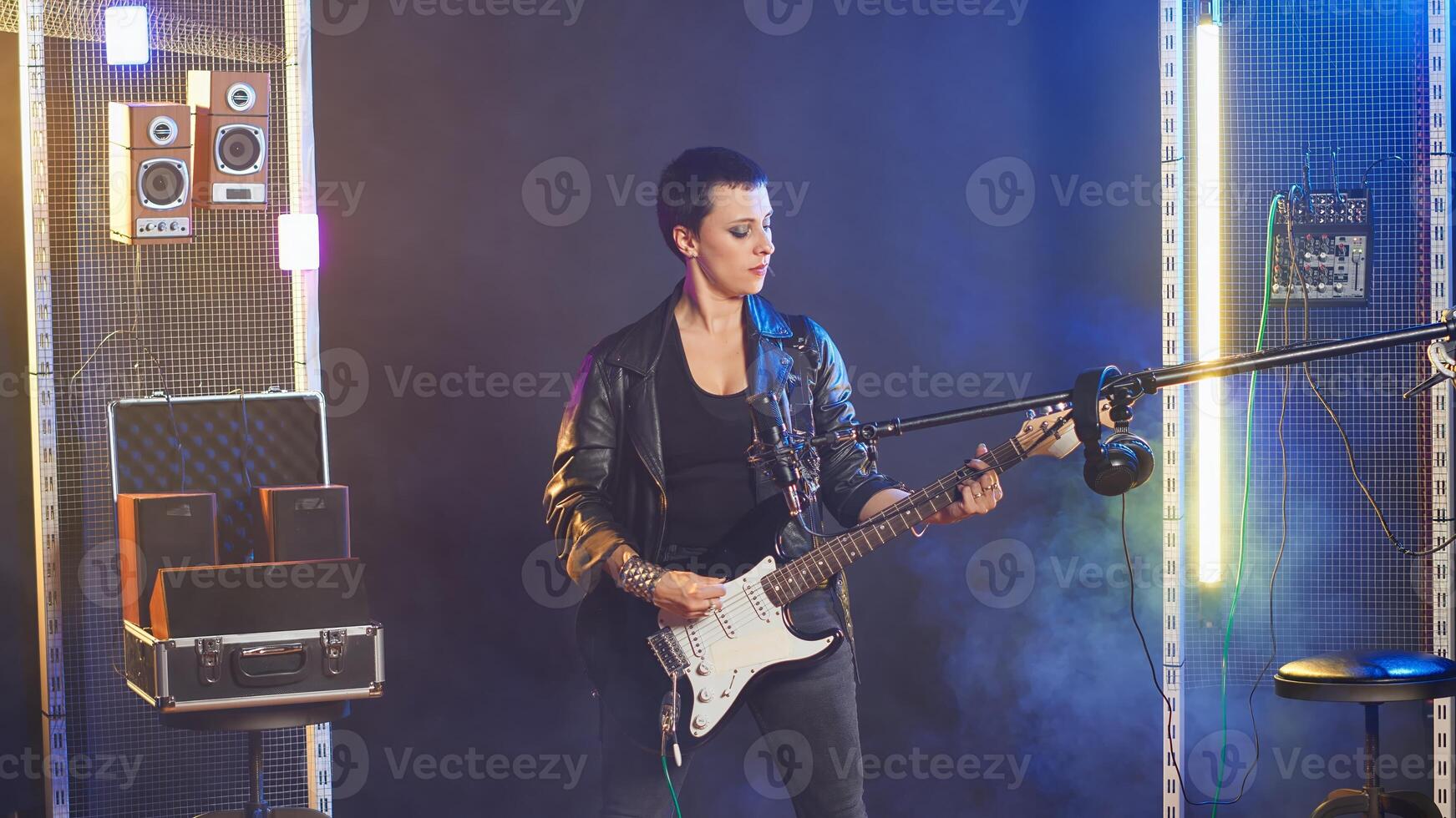 Female rock performer belts out lyrics in a thrash metal concert, showing her powerful voice and rebellious attitude captivating the crowd. Rock star doing a fierce music performance. Camera B. photo