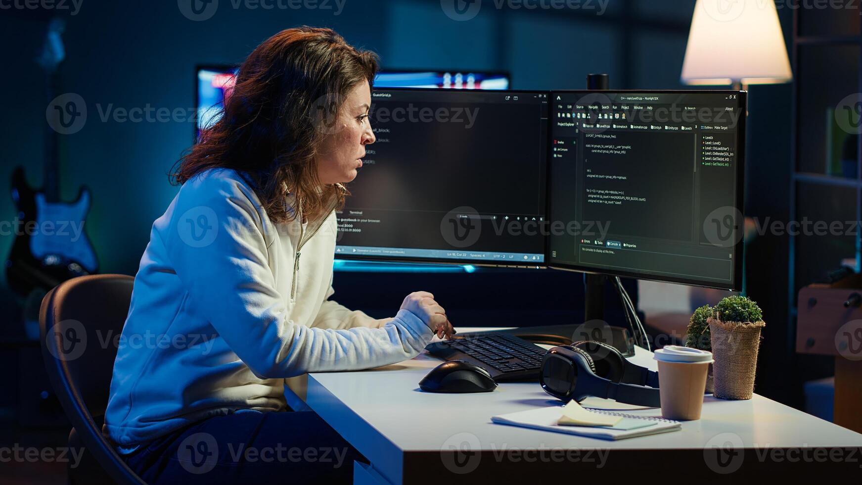 IT expert working from home developing software in JavaScript programming language using desktop PC. System engineer in living room writing lines of code on computer using keyboard, camera A photo