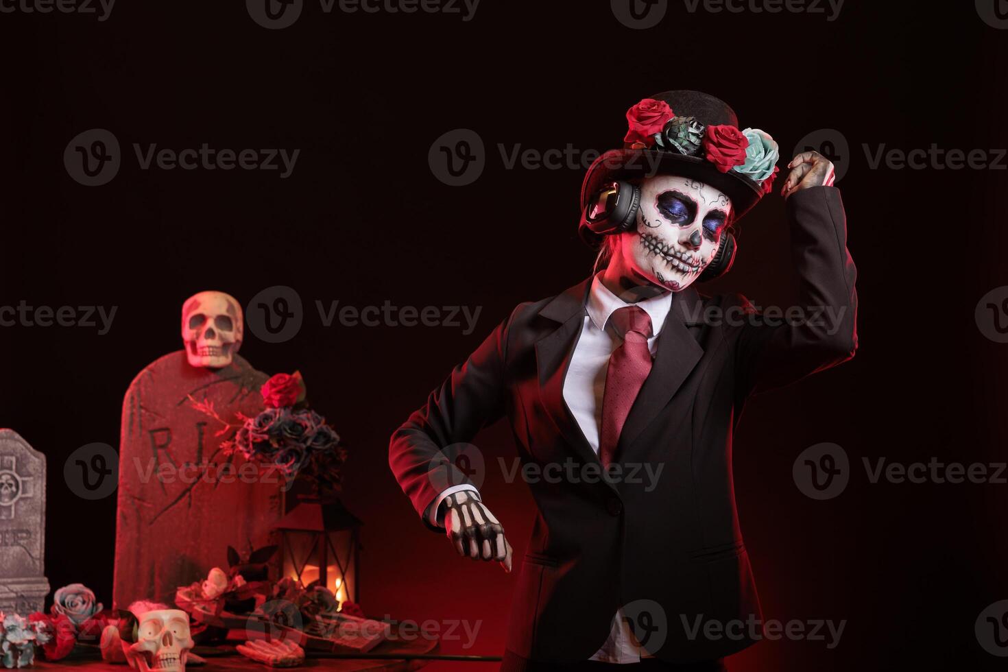 Woman dancing in studio, listening music during Day of the Dead Mexican event honoring dead loved ones. Person with headphones doing dance moves during ancient Aztec custom of celebrating ancestors photo