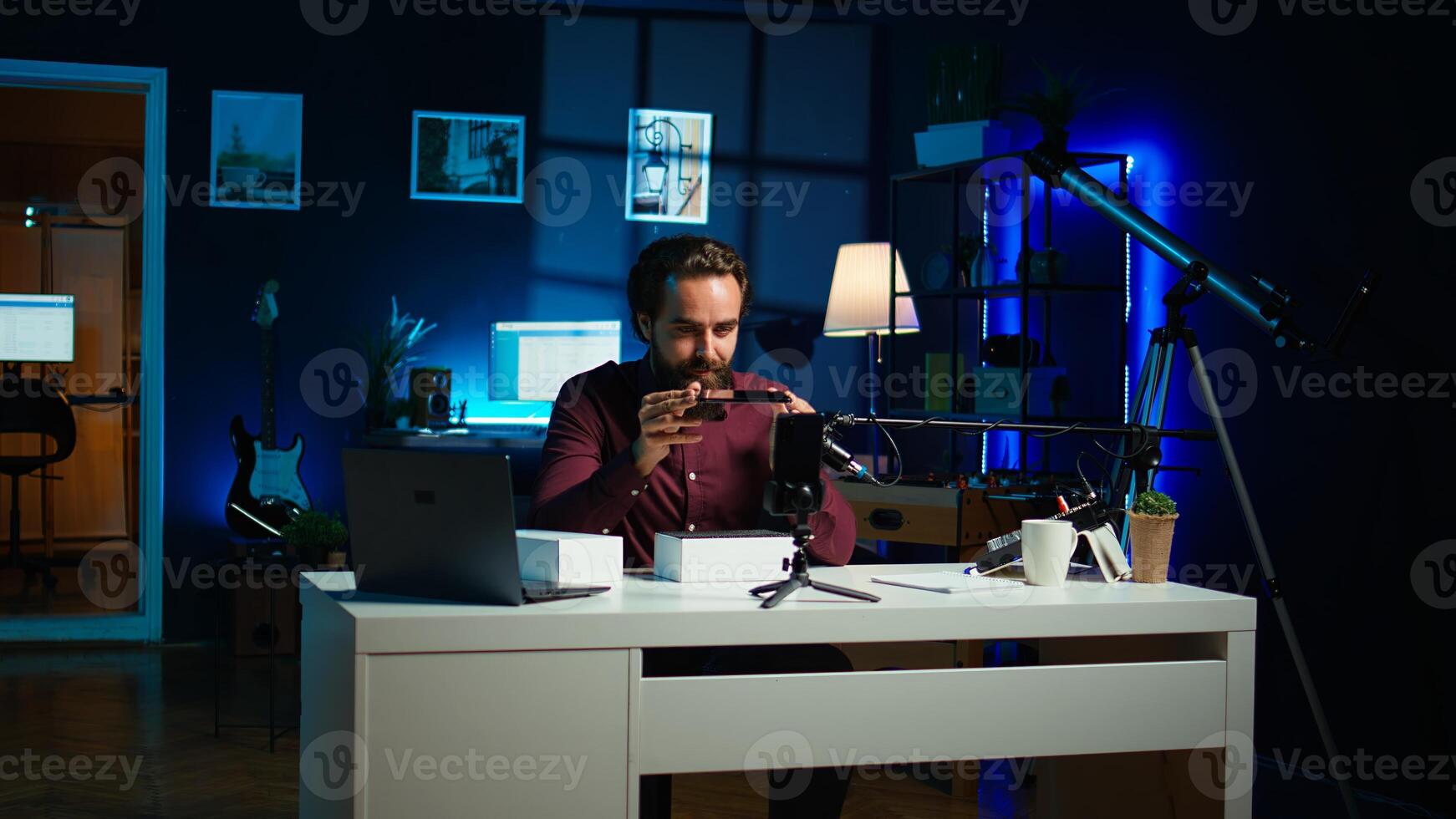 Entertainer presents smartphone from sponsoring brand, closely analyzing features. Content creator reviewing phone for tech enthusiasts watching his internet channel, inspecting materials, camera B photo
