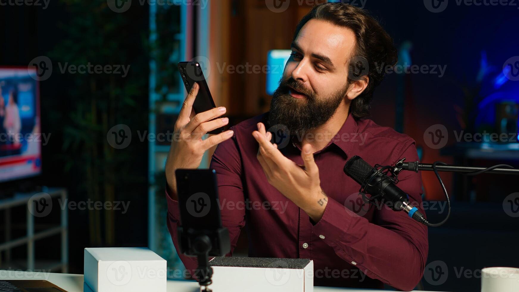 Entertainer presents smartphone from sponsoring brand, closely analyzing features. Content creator reviewing phone for tech enthusiasts watching his internet channel, inspecting materials, camera A photo