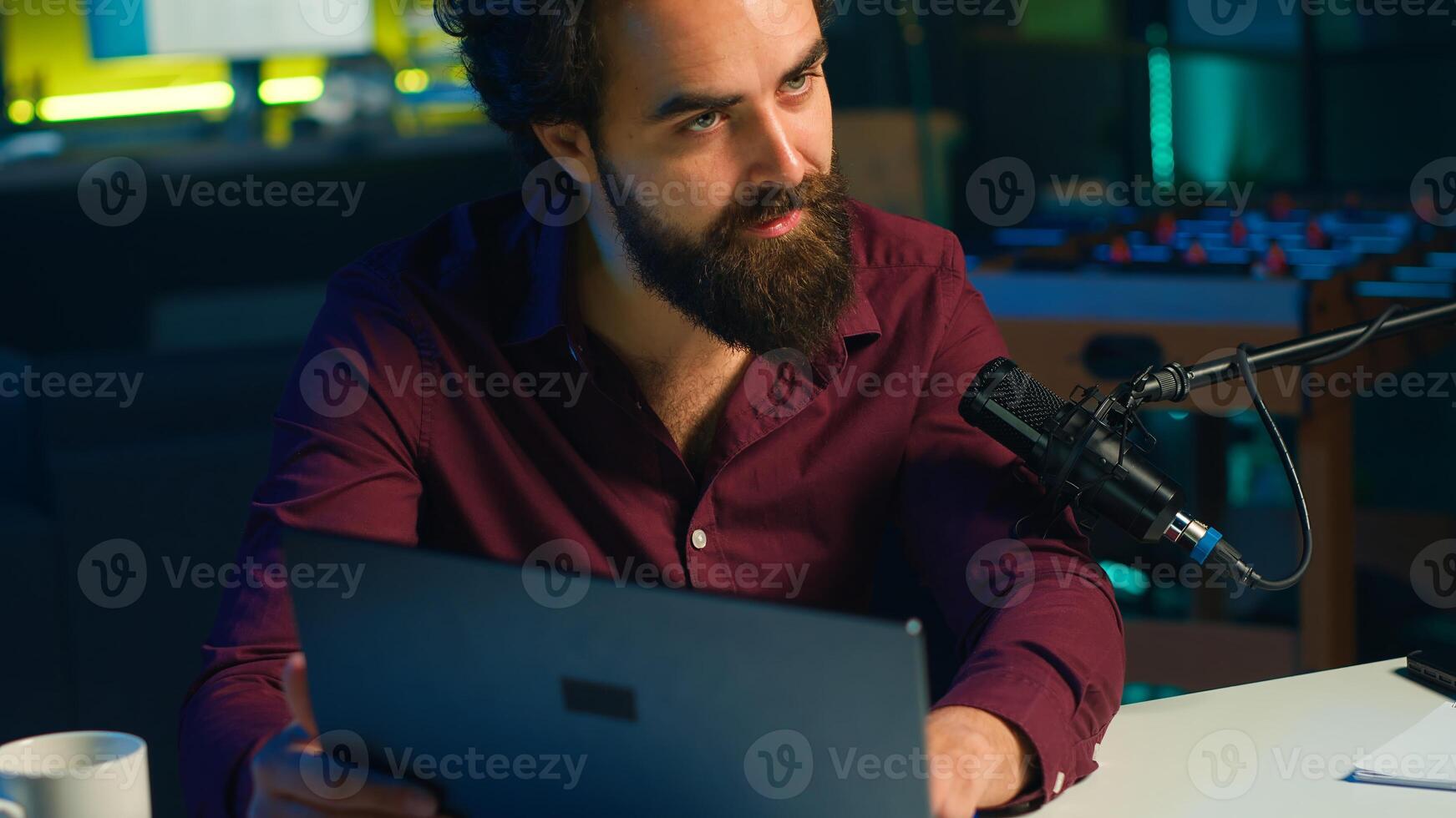 Tech content creator filming review of newly released gaming laptop, unboxing it and giving feedback to his fanbase. Internet star endorsing sponsor branded device to subscribers, camera A photo