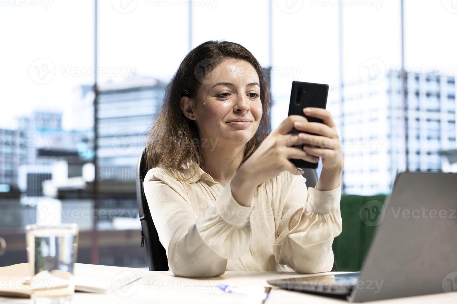 Female CEO discussing business ideas with her team on social media, receiving project updates form employees via text messages. Successful goal oriented entrepreneur with determination. photo