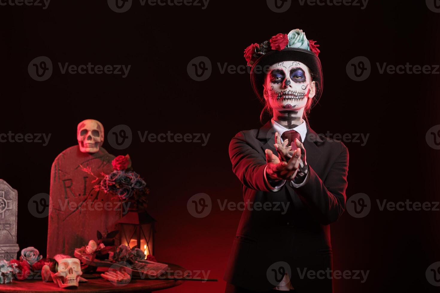 Portrait of mysterious lady doing provocative luring gesturing at Dia de los Muertes indigenous rites. Woman doing enticing hand invitation at Day of the Dead celebration in honor of the deceased photo