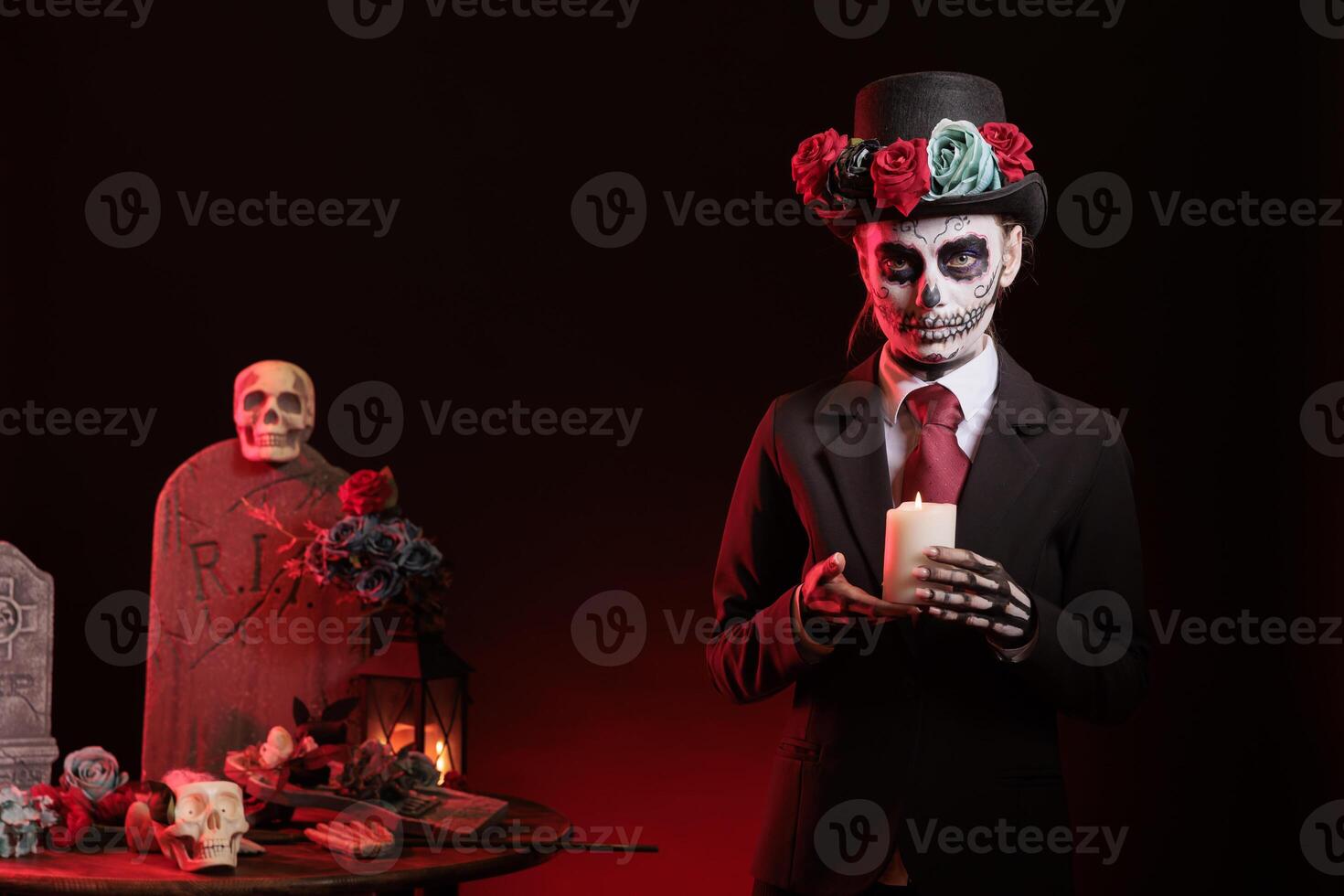 Woman lighting candle during Dia de los Muertes indigenous rites of honoring the dead. Lady with candlestick on fire participating in Day of the Dead, Mexico annual event in honor of the deceased photo