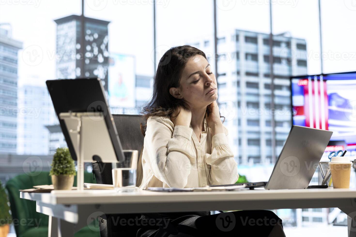 Woman boss suffers from office syndrome due to incorrect pose at the desk, having neck and back ache while she works on her business. Female leader with cramps and sedentary life. photo