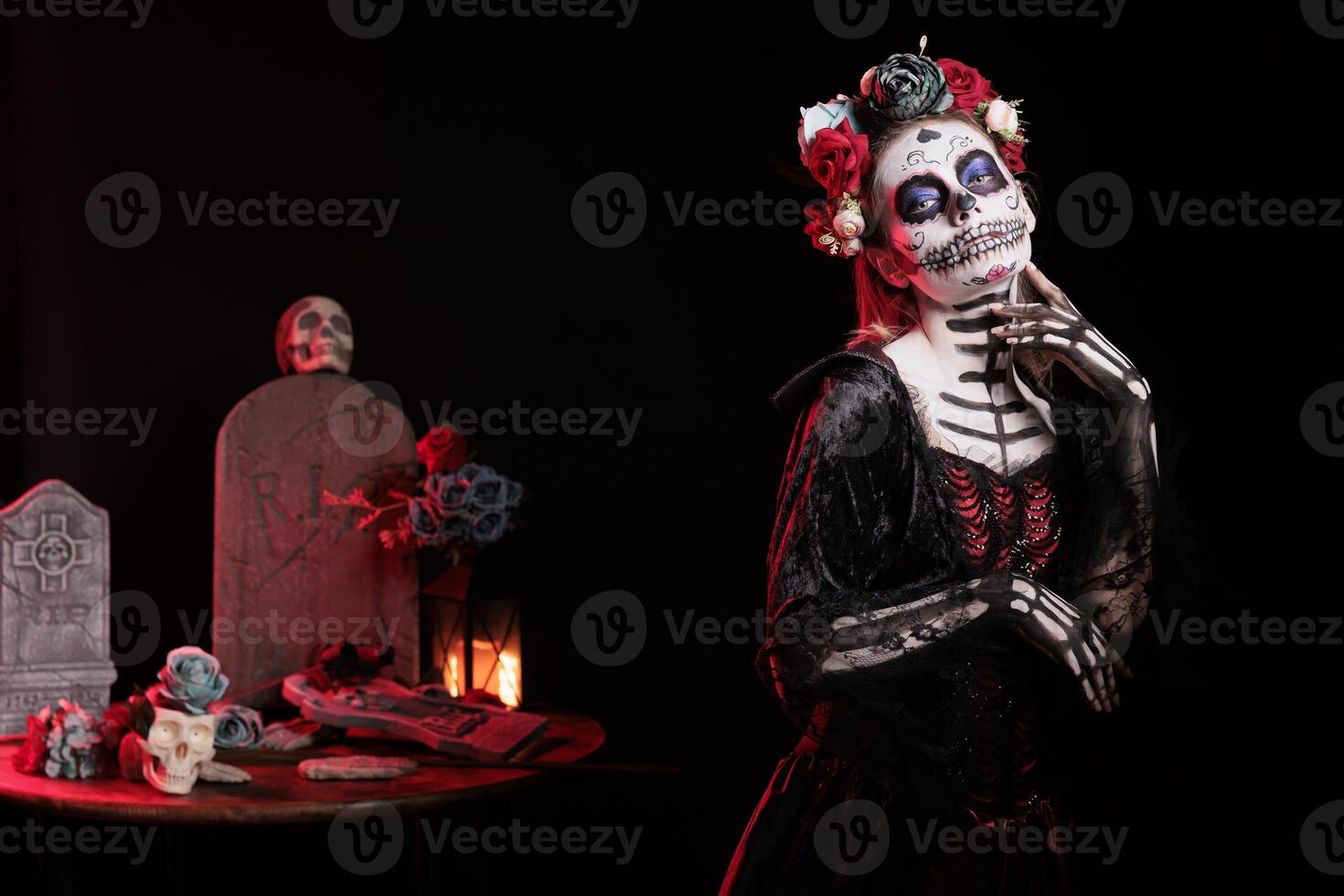 Portrait of woman posing with finger on chin for Day of the Dead Mexican celebration honoring dead loved ones. Person doing ancient Aztec custom of celebrating ancestors, wearing skull face paint photo