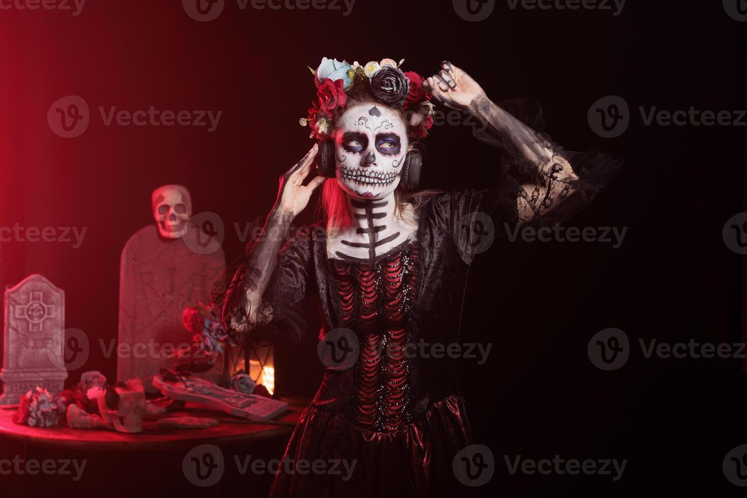 Woman listening music during Day of the Dead Mexican event honoring dead loved ones. Person wearing headphones hearing songs during ancient Aztec custom of celebrating ancestors photo