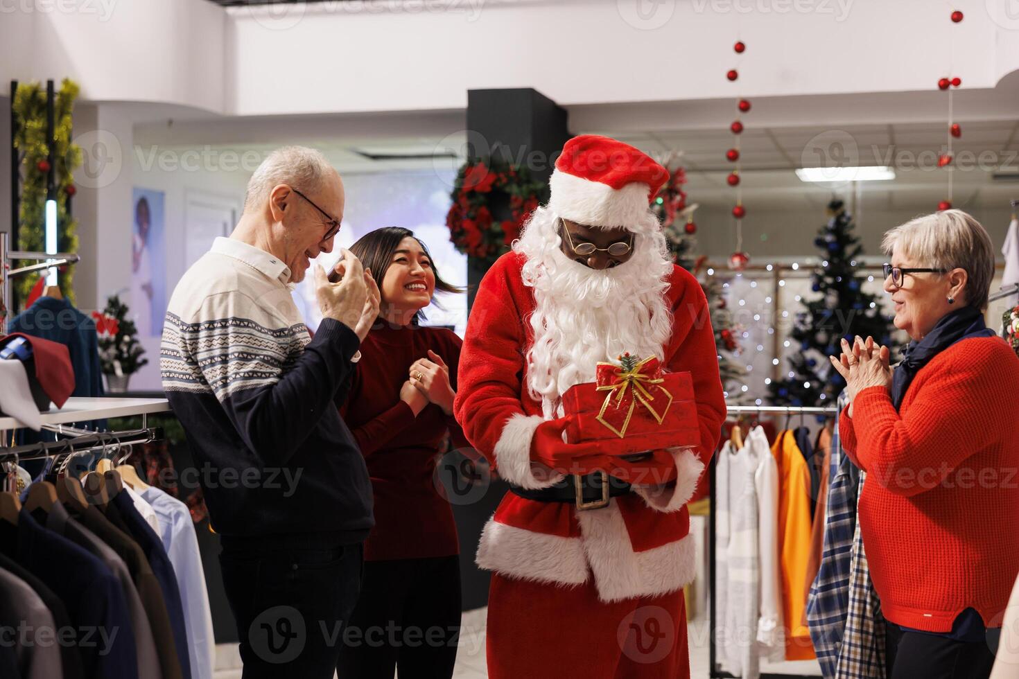 Retail worker reading names on papers to announce winner of december raffle contest in shopping mall, giving prize to client during christmas holiday. Diverse people waiting to see who won. photo