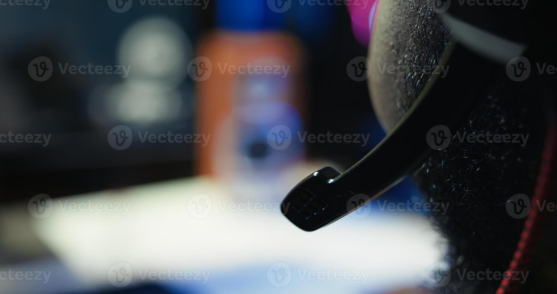 Man having fun playing videogames on PC while chatting with teammates through headphones mic. Close up of gamer battling rival players, communicating with friends through headset microphone, camera B photo