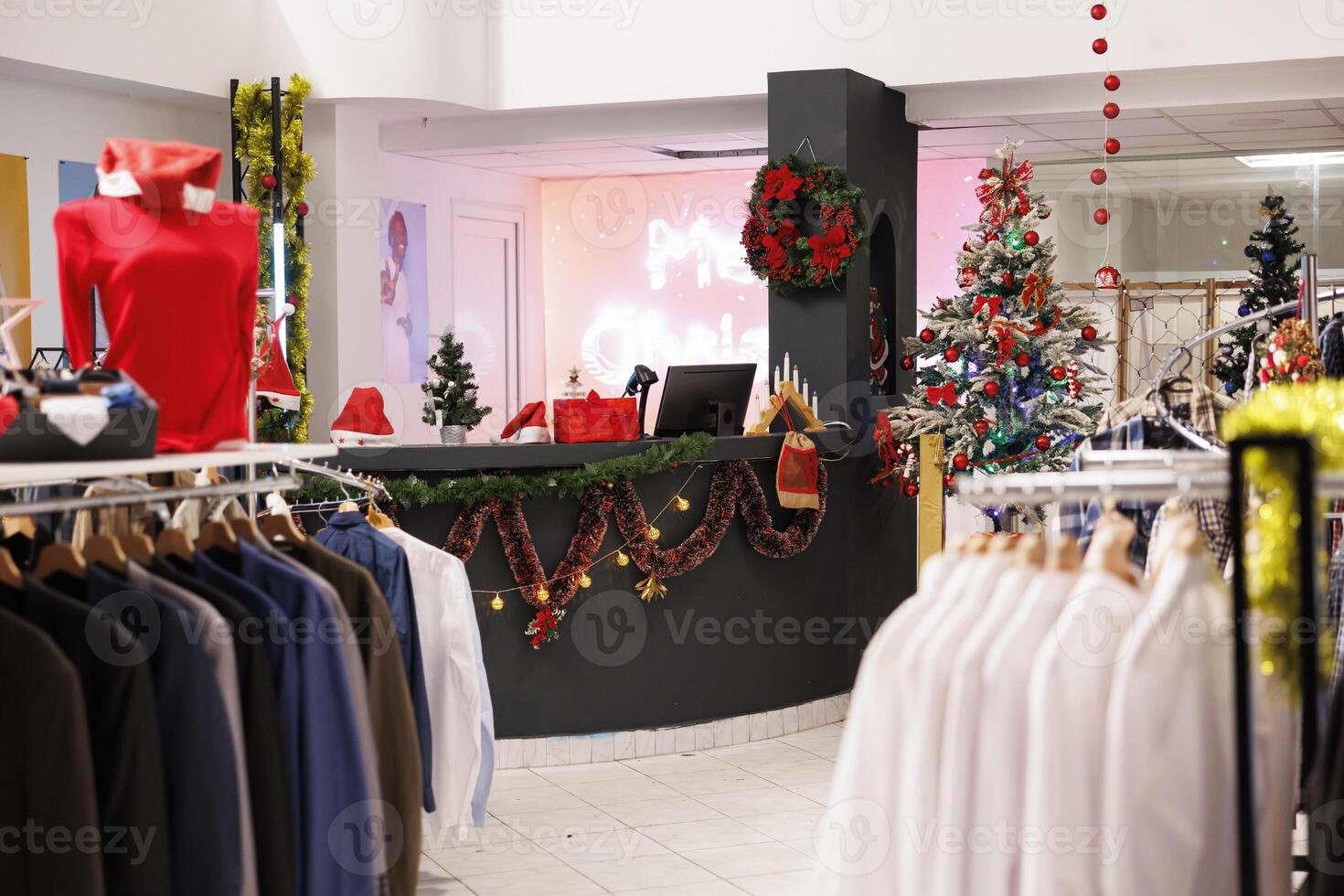 December holiday spirit in retail store, xmas decorated clothing store announcing Christmas sales. Promotional prices on clothes to buy as presents, mall boutique with variety of racks. photo