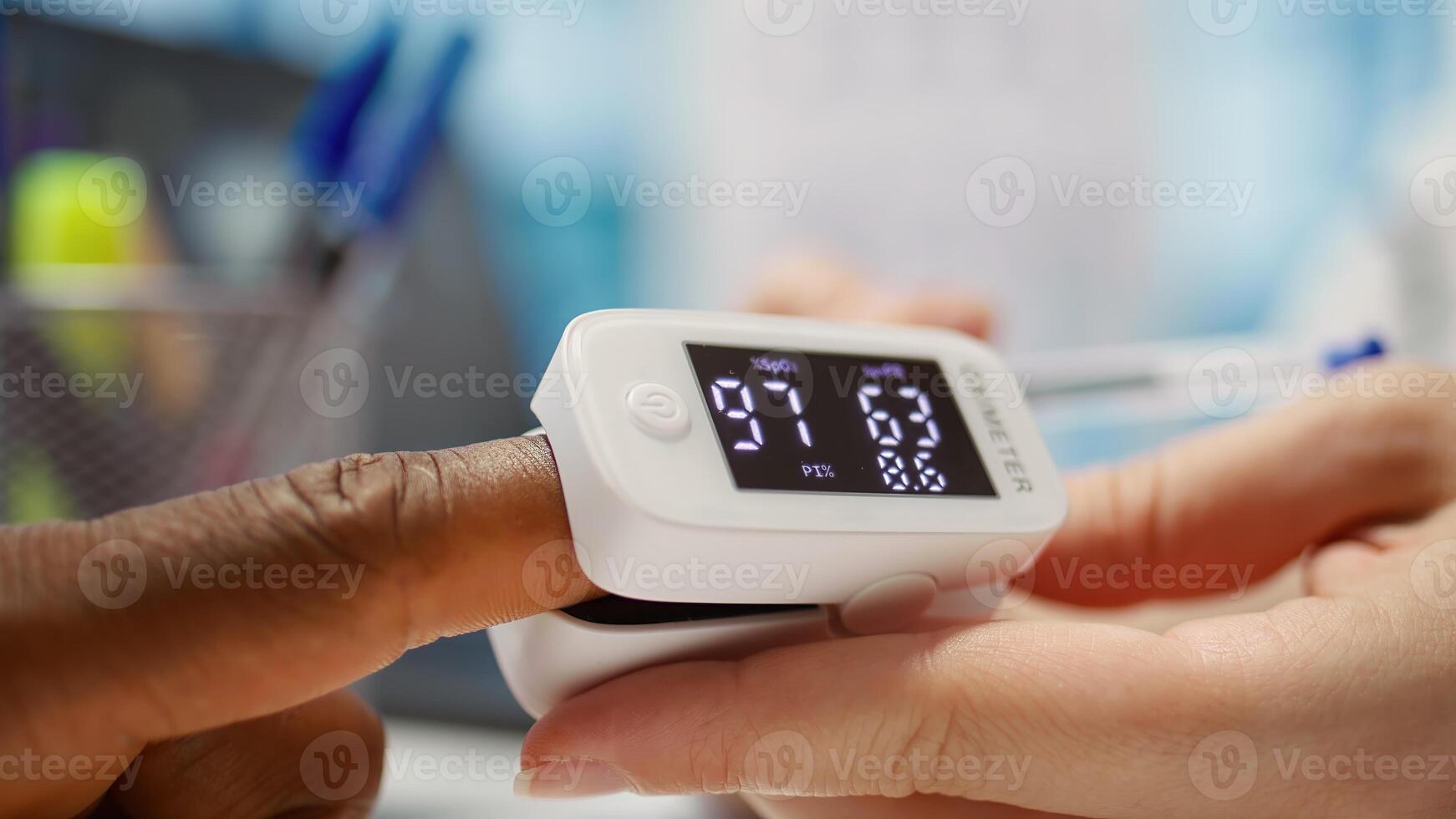 Medical specialist takes the oxygen saturation measurement and checking vital signs during a routine check up with her patient. Medic using an oximeter for accurate readings in office. Camera B. photo