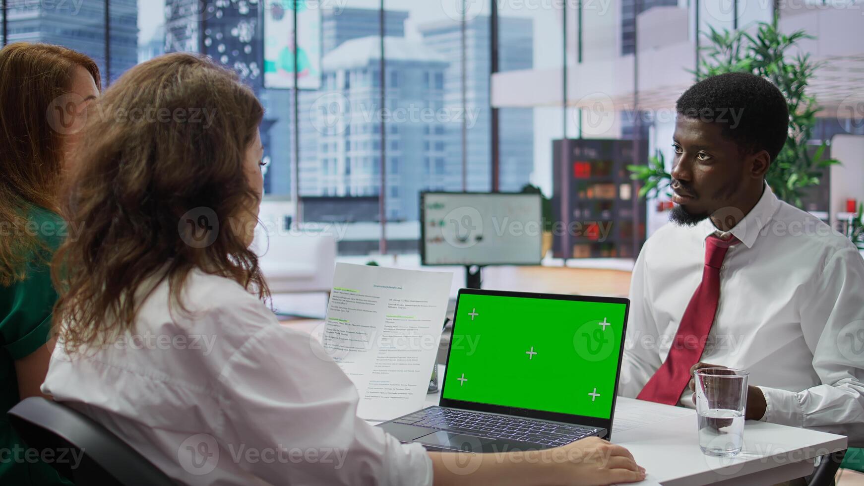 HR manager doing a job interview with candidate by using laptop with chroma key mockup, asking questions about his studies and qualifications. Businesswoman meeting with applicant. Camera B. photo
