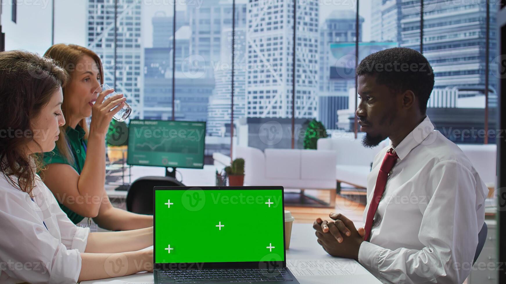 Interviewers meeting with a job candidate about a vacancy next to green screen, HR team attending interview with applicant during recruitment process. Headhunting concept. Camera B. photo