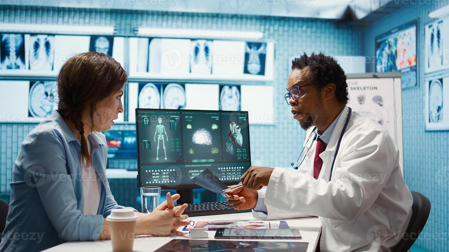 Medical expert specialist explaining the x ray imaging for a diagnosis, doing scan interpretation during check up consultation. Professional medic gives feedback to female client. Camera B. photo
