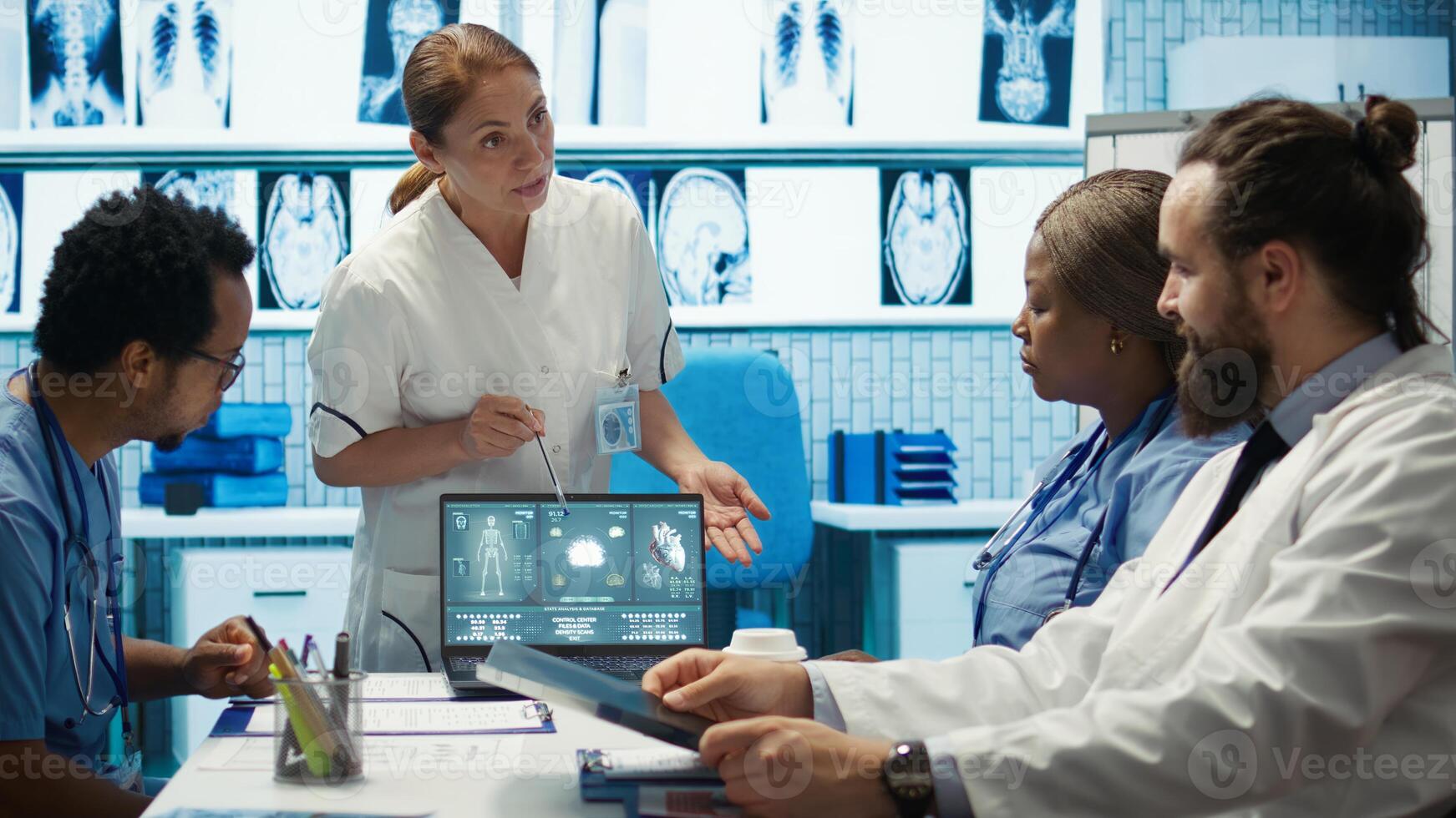 Team of doctors review electrocardiogram test results at a private facility, analyzing human organs on a radiography for disease prevention. Consulting hospital records and cardiology scan. Camera B. photo