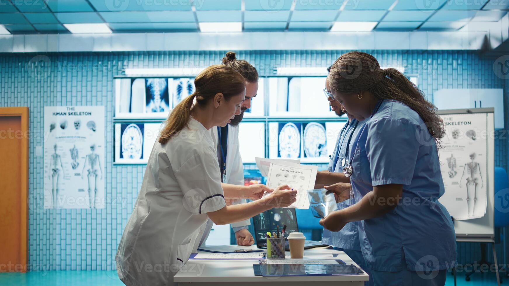 Hospital staff reviews human anatomy to give the correct diagnostic in a cabinet meeting. Group of medics ensure accurate treatment service for disease prevention, radiology department. Camera B. photo