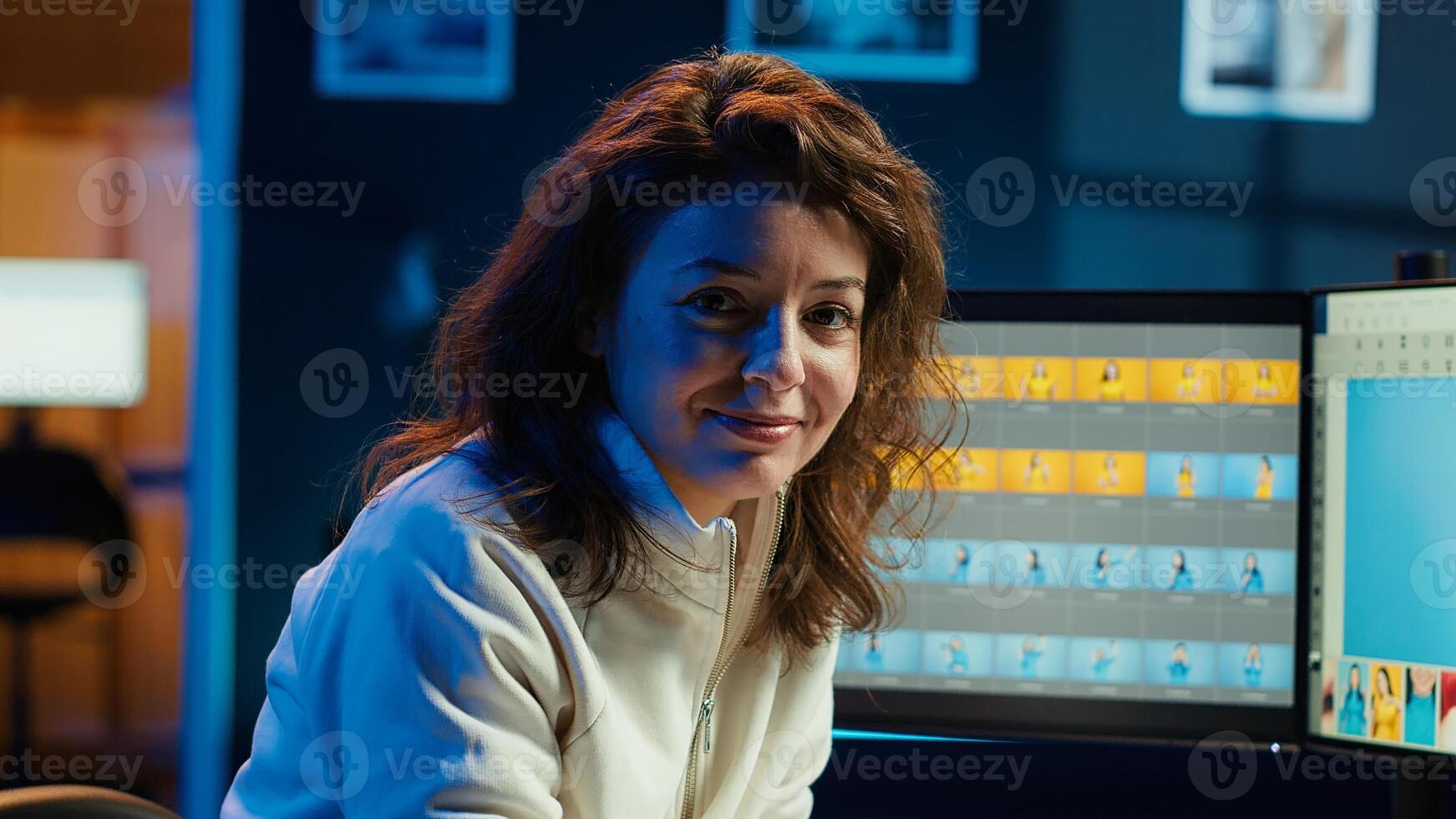 Portrait of photo editor browsing through images to determine the most appropriate visuals for publication in magazines. Smiling photographer manipulating images in creative studio, camera A close up