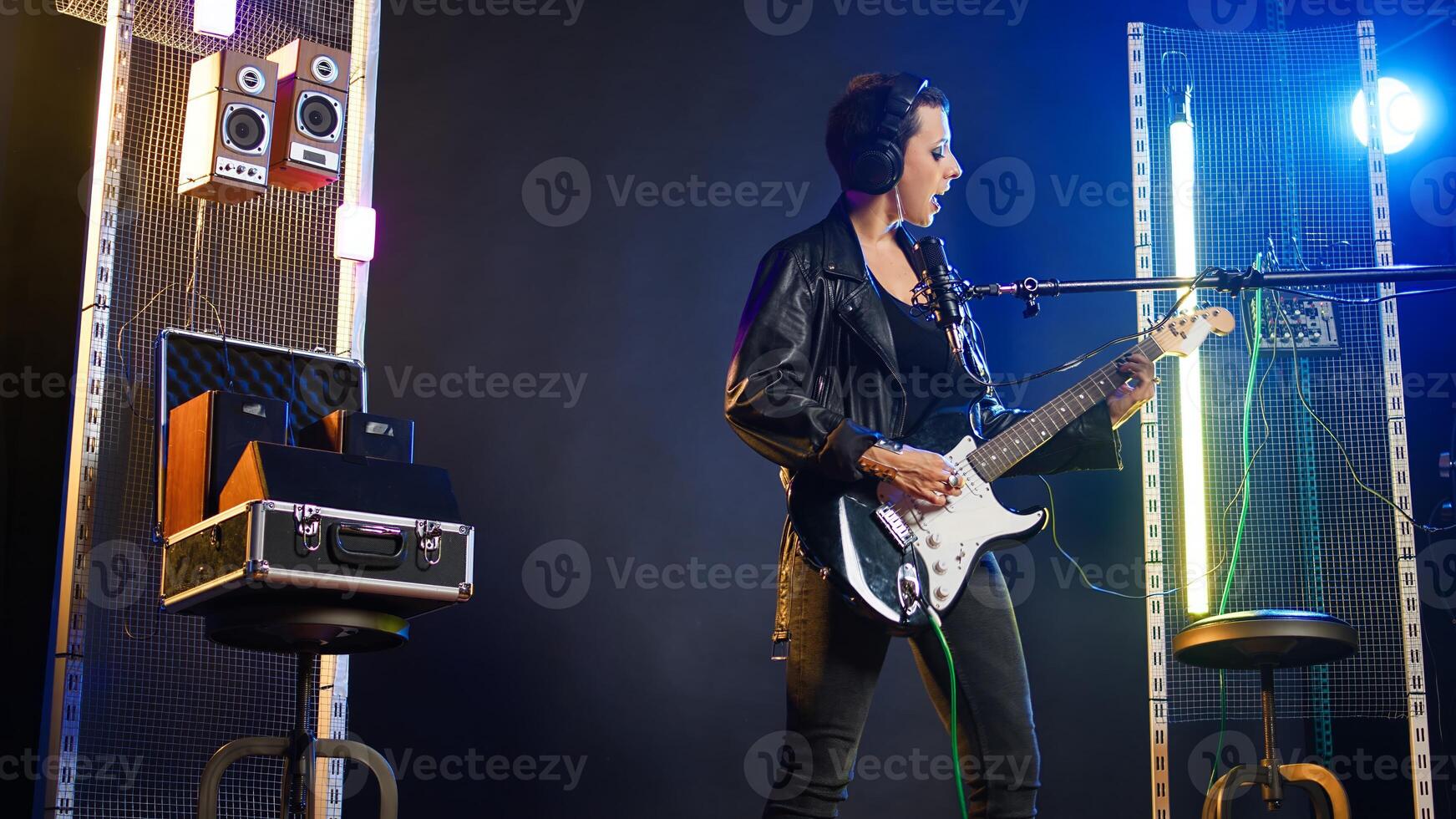 Rock star singing in a dark grunge nightclub with her bass guitar, delivering a bold vocal performance with edgy rebellious energy. Fierce musician with an iconic voice and cool attitude. Camera A. photo