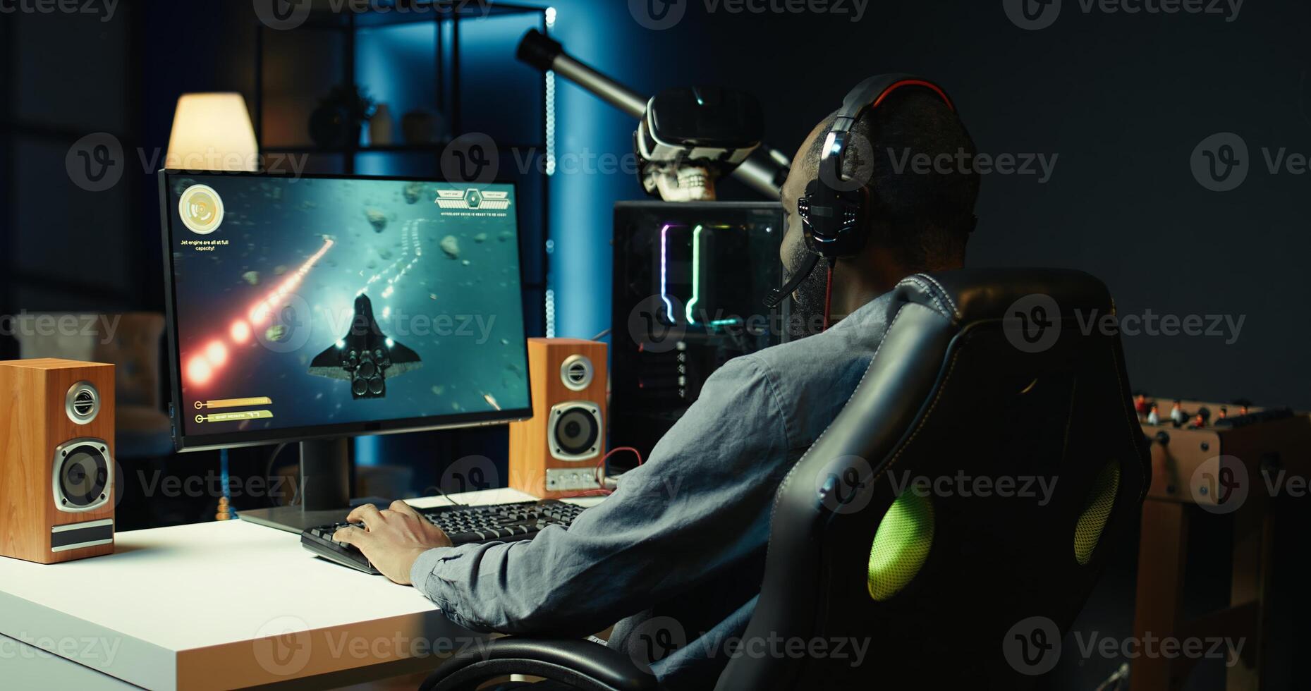 Man playing SF shooter videogame on computer monitor, talking into headset with friends. Gamer using headphones while enjoying game with spaceship flying to chat with Esports team, camera B photo