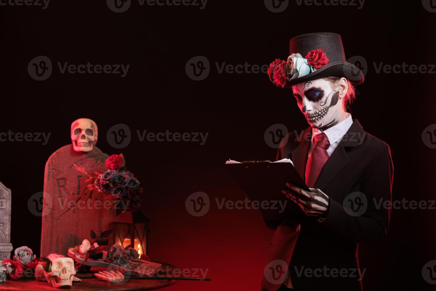 Woman looking over paperwork documents at Day of the Dead event to remember the deceased. Lady holding clipboard, checking inventory of Mexican holiday of remembrance for those who have passed photo