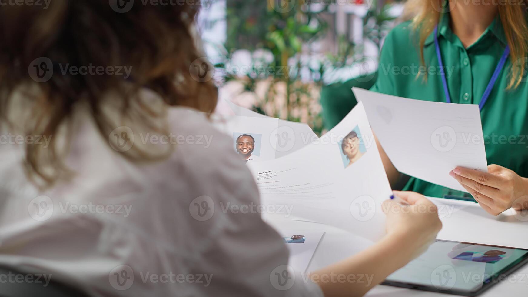 Human resources staff evaluating candidates resume in the selection process, reviewing all applicants after job interview in order to hire the right person. Recruiters seeking personnel. Camera A. photo