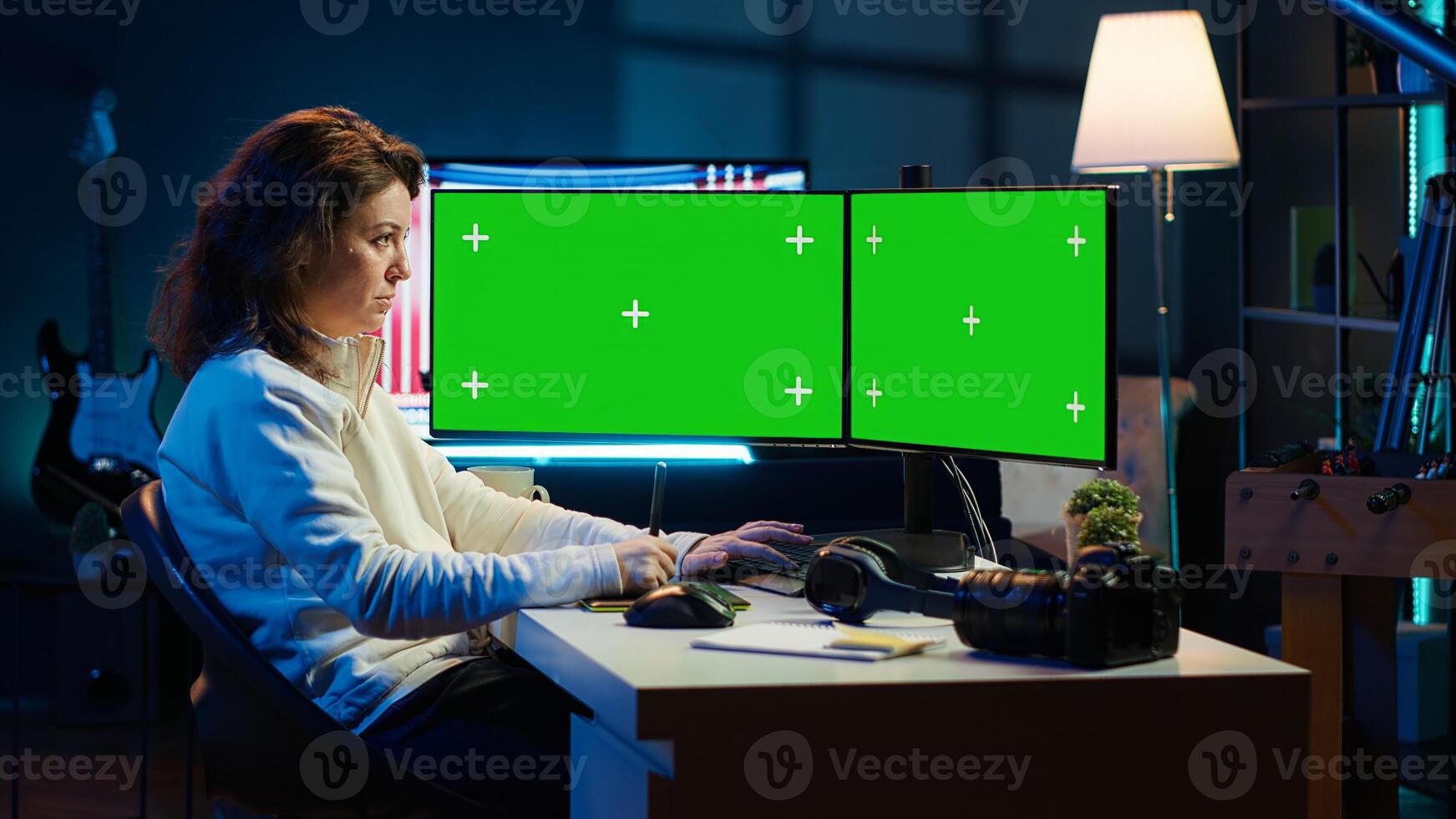 Photographer using photo editing software on chroma key multi monitors setup to improve images quality. Photo editor utilizing pictures retouching application on green screen display, camera A