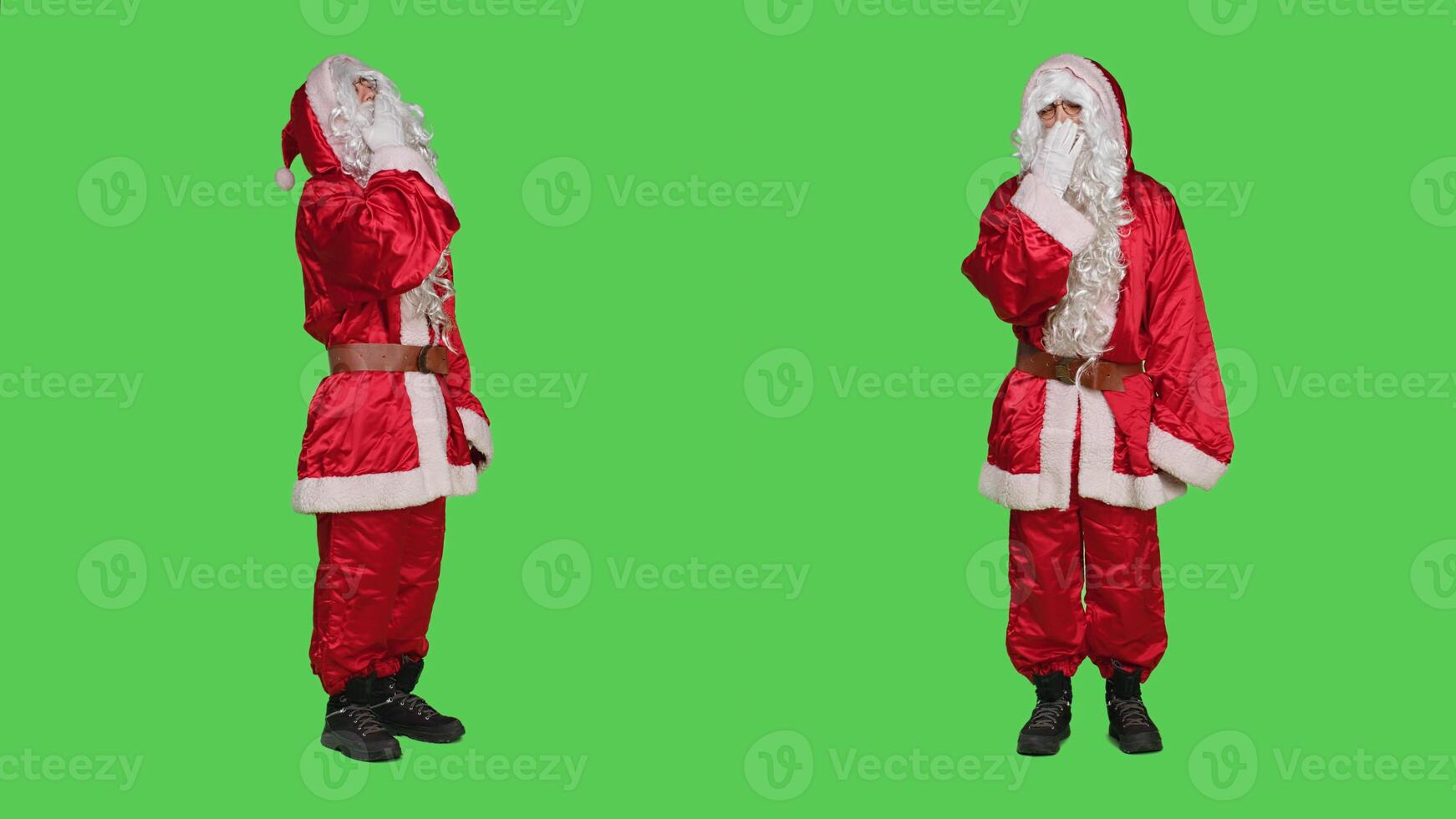 Santa cosplay feeling tired yawning over full body greenscreen backdrop, falling asleep while he wears saint nick costume with hat. Adult in red suit being sleepy overworked. photo