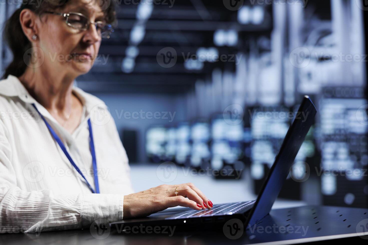 Senior qualified IT developer inside high tech facility providing computing resources needed for AI to process extensive datasets for training. Server rows storing data used for machine learning photo