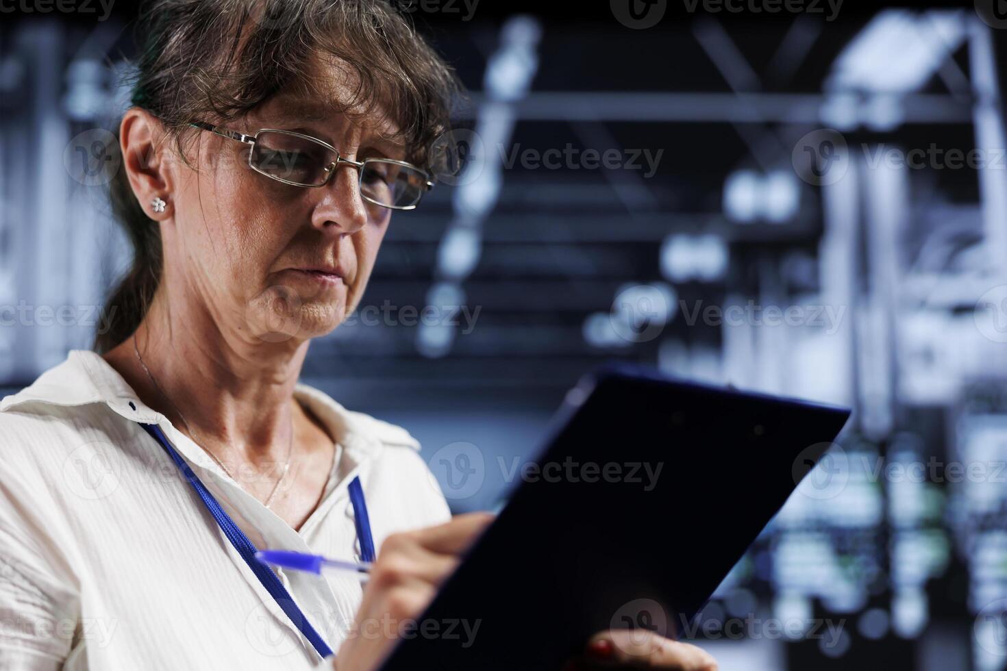 Octogenarian computer scientist inside high tech facility providing computing resources needed for AI to process extensive datasets for training. Server racks storing data used for machine learning photo