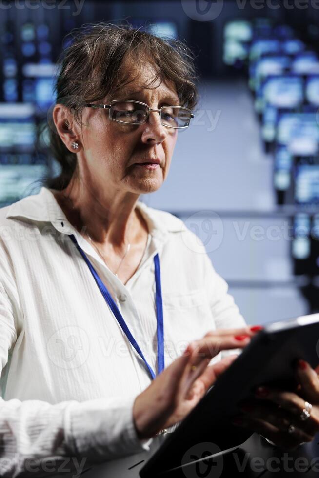 Certified technician preparing server rackmounts recovery plan, monitoring data center energy consumption across parts, making sure sensors are functioning errorlessly, doing annual disk checks photo