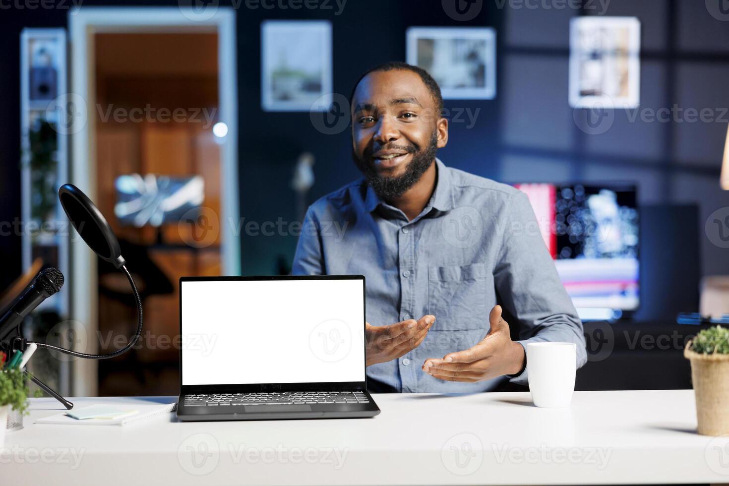 Influencer in home studio using recording tech to capture live broadcast, reviewing mockup laptop. Online show host filming electronics haul, presenting isolated screen notebook for viewers photo