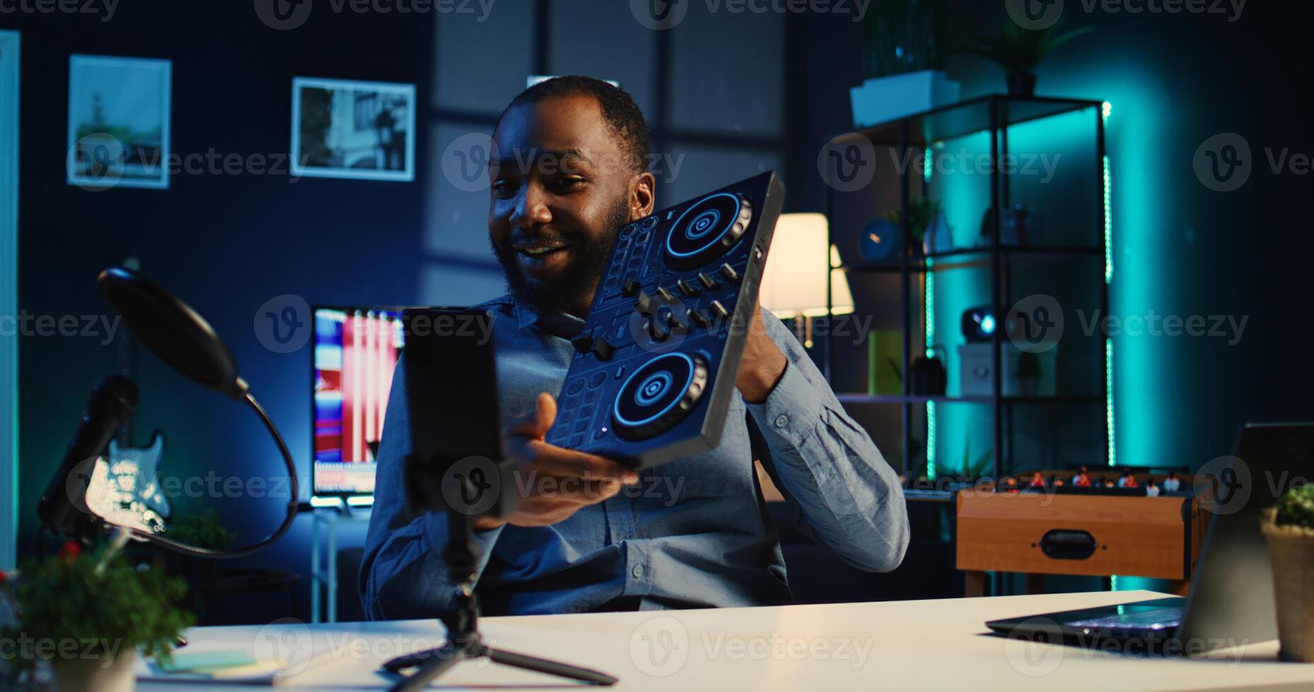 Artist filming DJ mixing tutorial in apartment studio, showing examples of sampling on sound controller to audience. Online star showing modern musical equipment to subscribers in living room photo