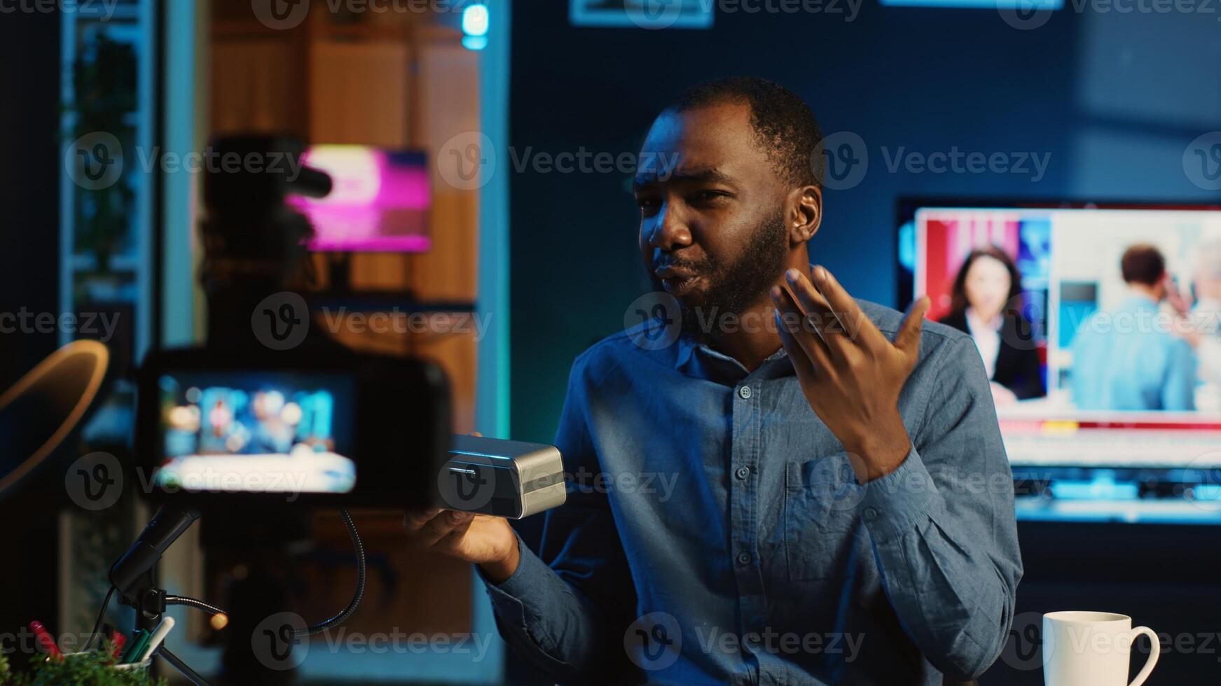 African american internet star doing technology review of wireless portable speaker for online platforms channel. BIPOC influencer presenting music playing device to his fanbase photo
