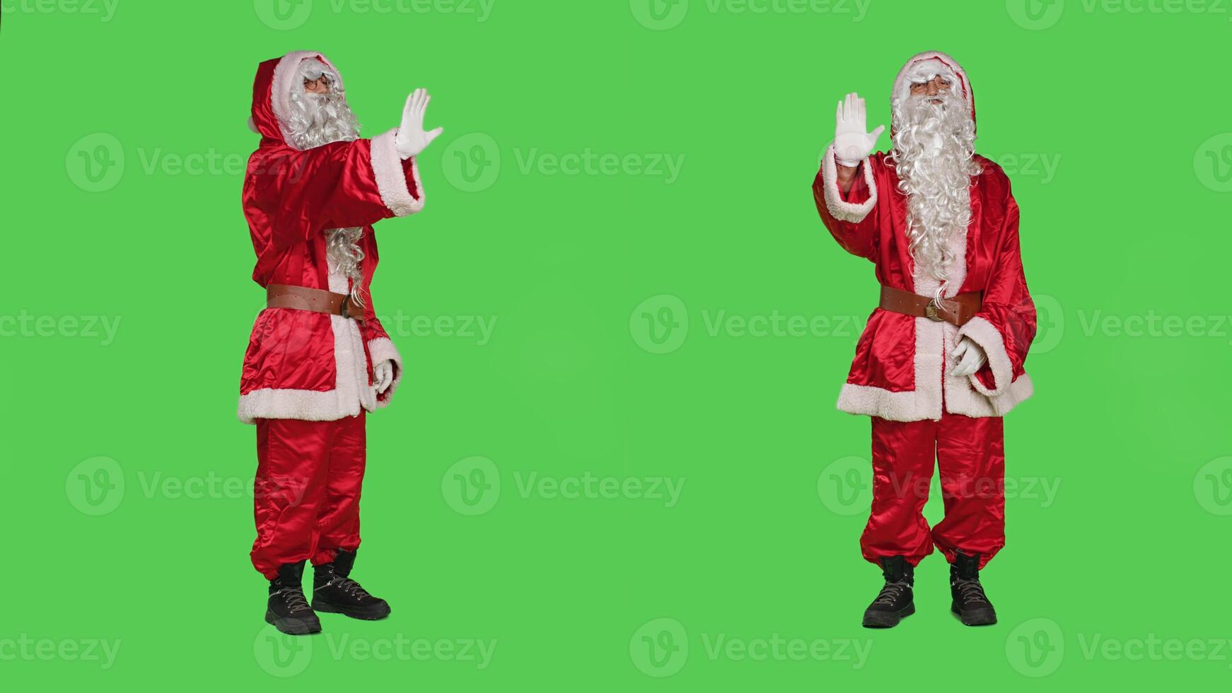 Christmas embodiment character shows palm as stop sign, rejecting ideas and acting displeased over full body greenscreen. Santa claus doing no symbol to refuse something, disapproval. photo