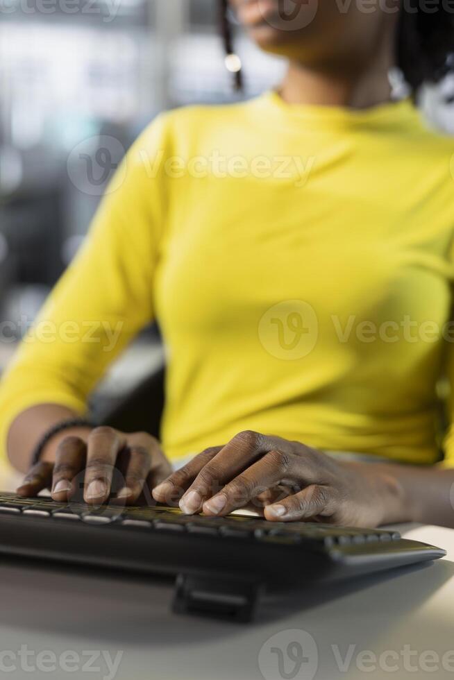 Meticulous accountant imputing revenue figures on computer in office. Adept employee at desk focused on typing company statistical numbers, working hard to finish job before deadline photo