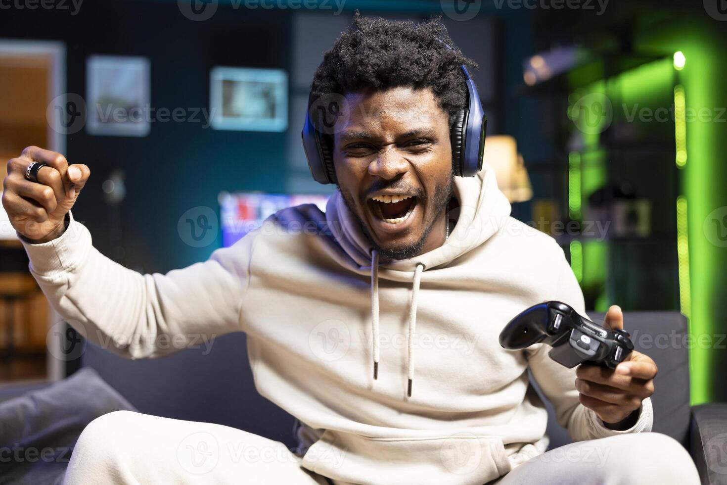 Happy gamer feeling excited after finally defeating all foes and winning game, celebrating, punching air. Joyous man congratulating himself after finishing videogame on gaming console photo