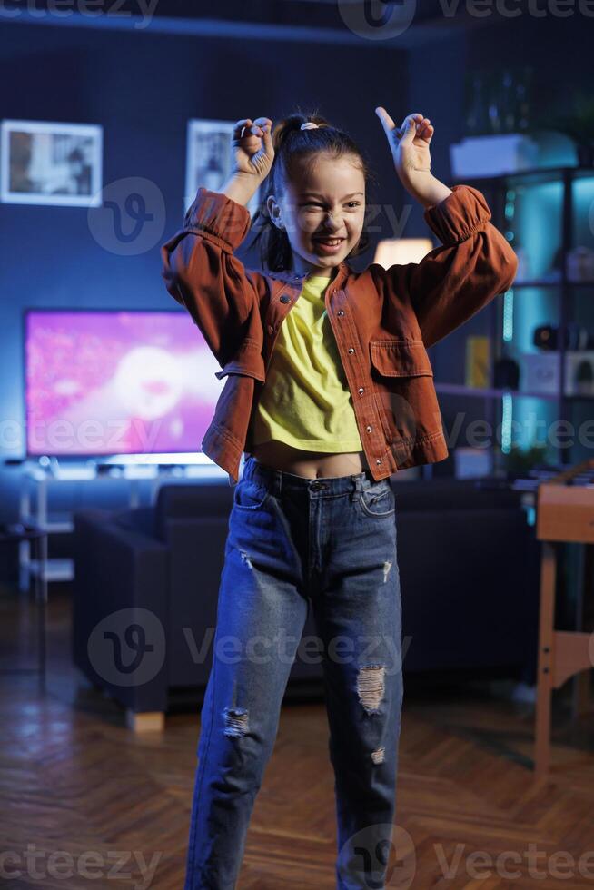 Lively child showcasing enchanting dance routine on social media platform, participating in online challenge. Cheerful youngster filming in home studio for internet audience photo
