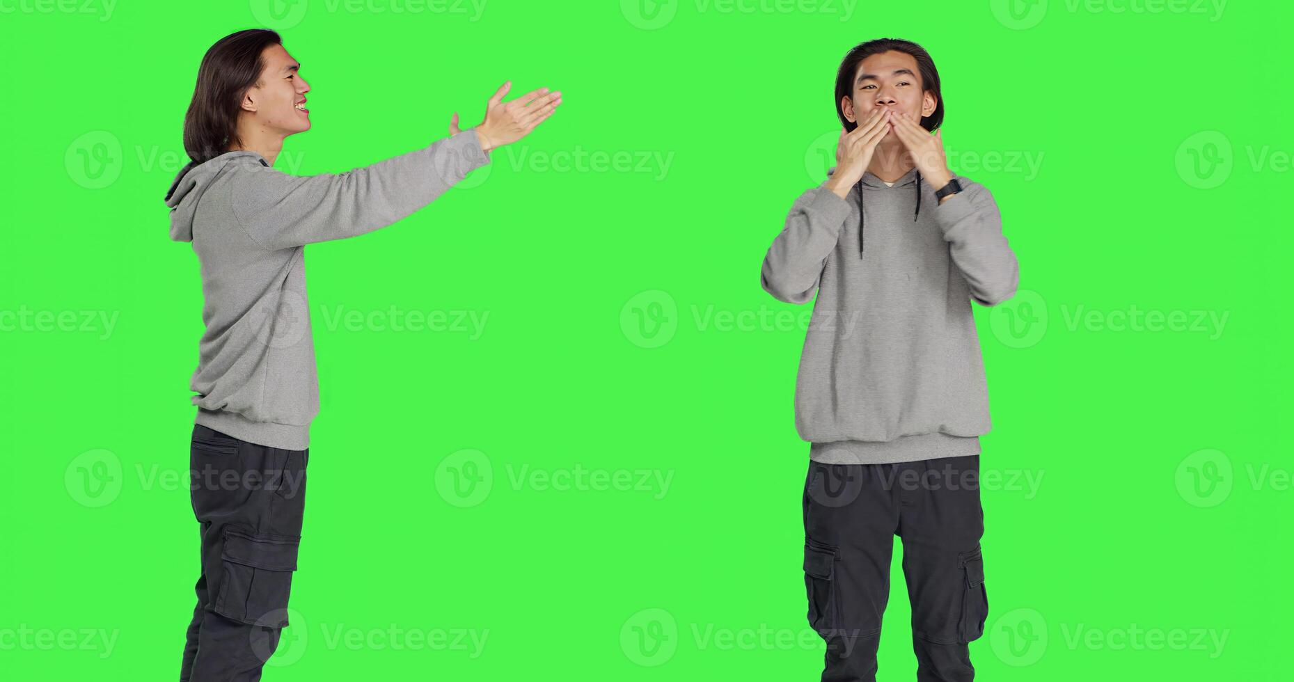 Asian man sending air kisses in studio, acting romantic and sweet standing against greenscreen backdrop. Young person feeling confident and flirty showing true lovely emotions. photo